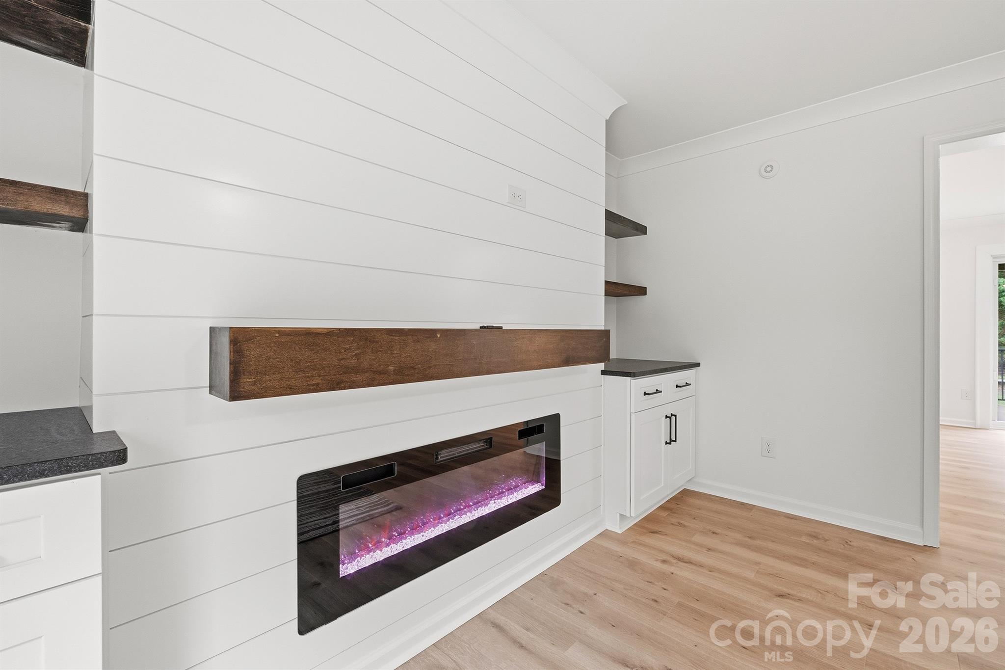 Electric fireplace with surrounding custom cabinets and floating shelves - 7553 Katherine Drive, Denver