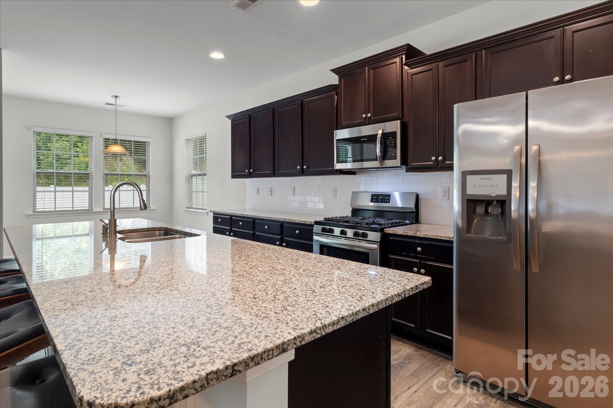 Gourmet kitchen with large island, granite countertops, stainless steel appliances (refrigerator stays for new owner) - 188 Cherry Birch Street, Mooresville