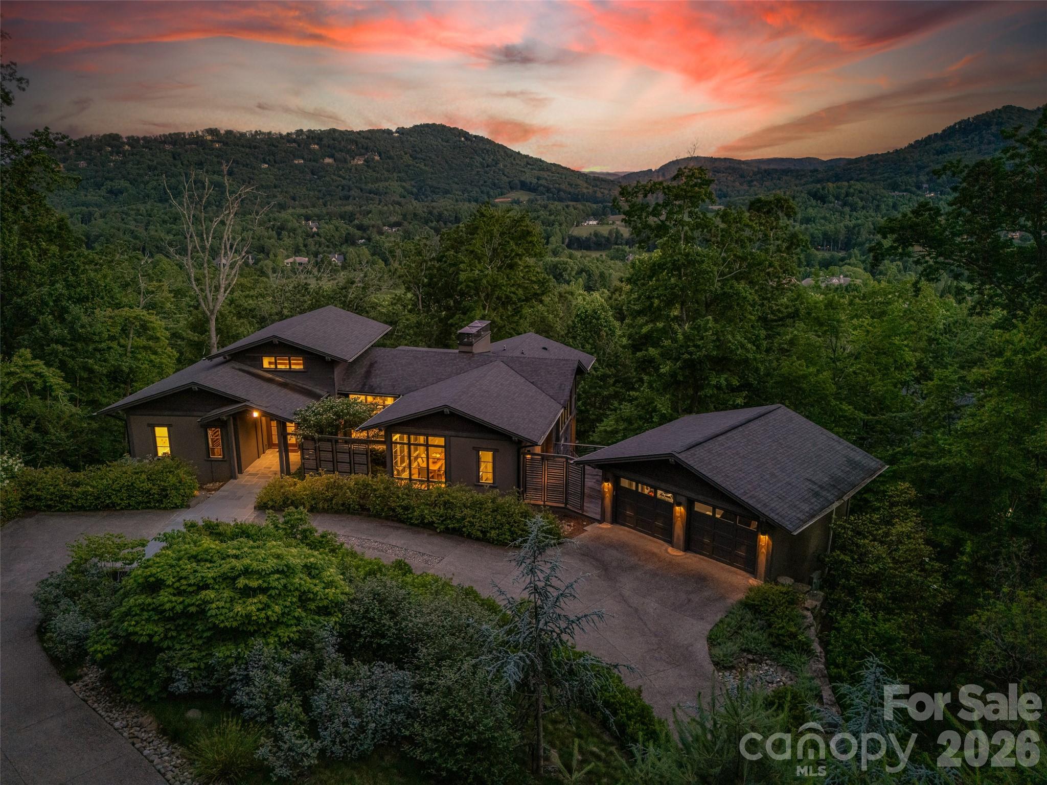 Twilight view showcasing the home's dramatic setting and architectural presence - 1121 Timberbluff Way, Arden