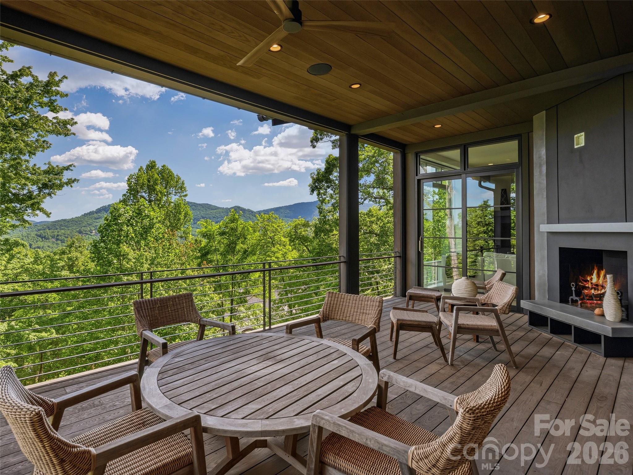 Covered porch featuring a stone fireplace for year-round enjoyment - 1121 Timberbluff Way, Arden