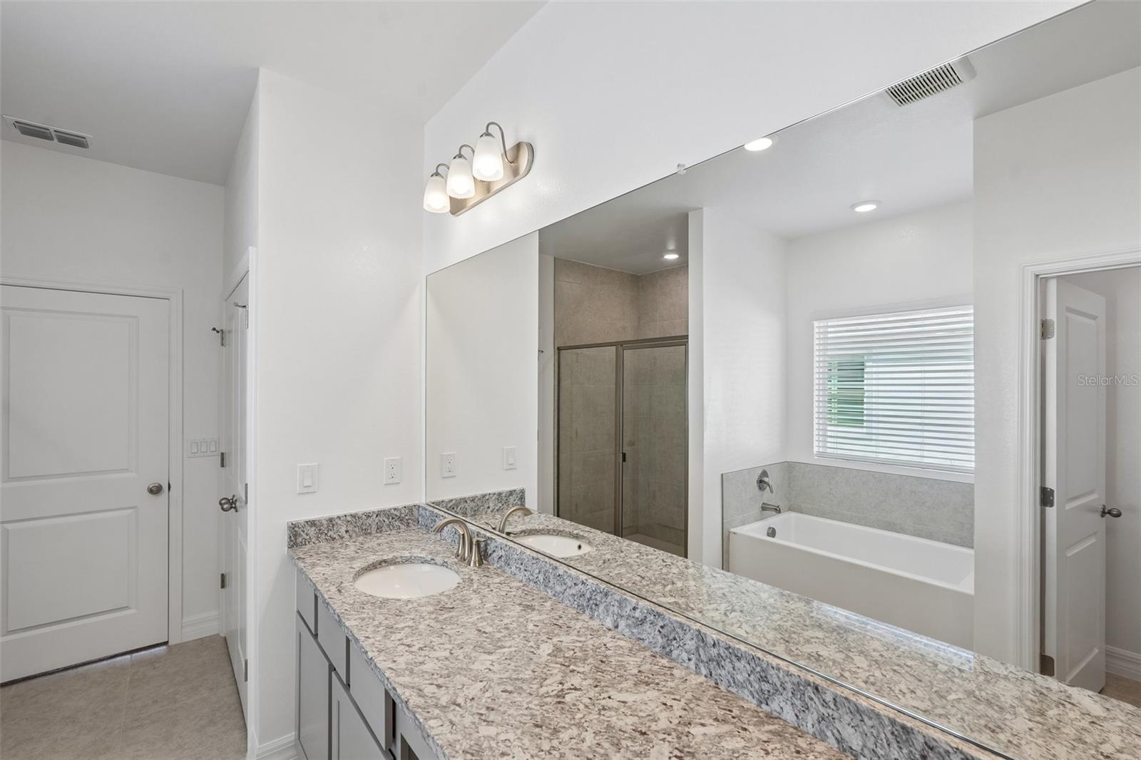 Primary Bath Granite Countertops, Tile Shower, Separate Tub, Dual Vanities - 25503 CALUSA DR, PUNTA GORDA