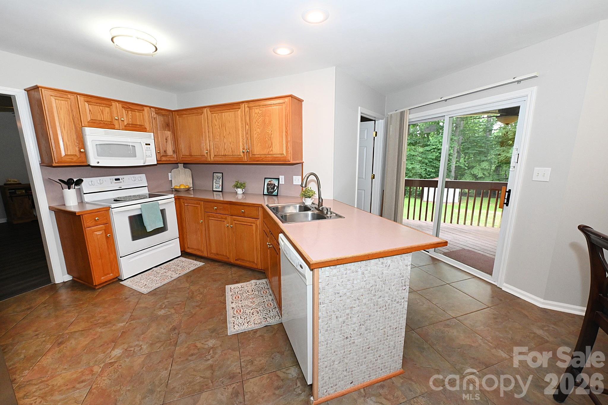 Kitchen with patio door leading to covered rear porch - 1035 E 24th Street, Newton