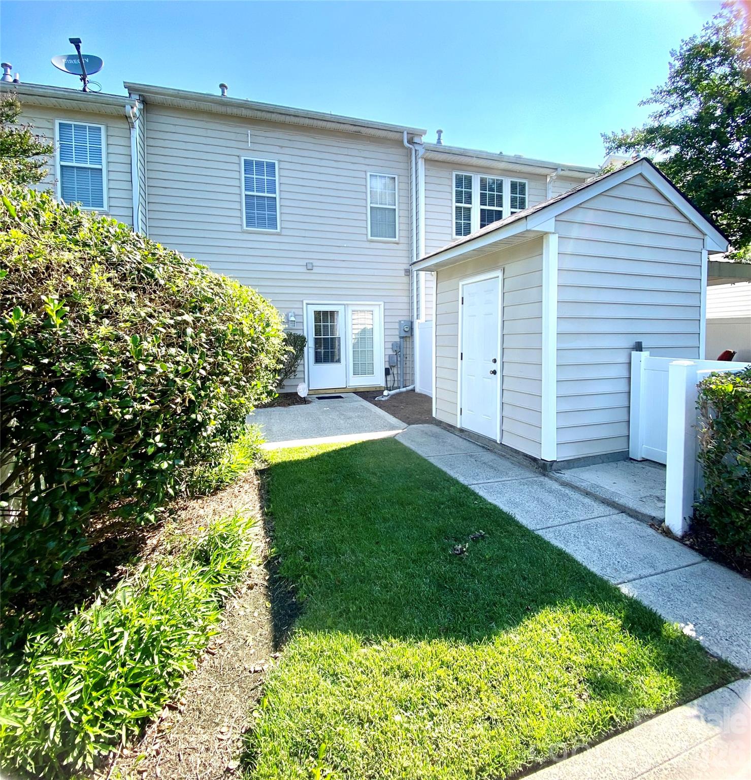 Rear View of townhome, patio, walkway, green area and parking pad freshly pressure washed May '26. - 6025 Creft Circle, Indian Trail