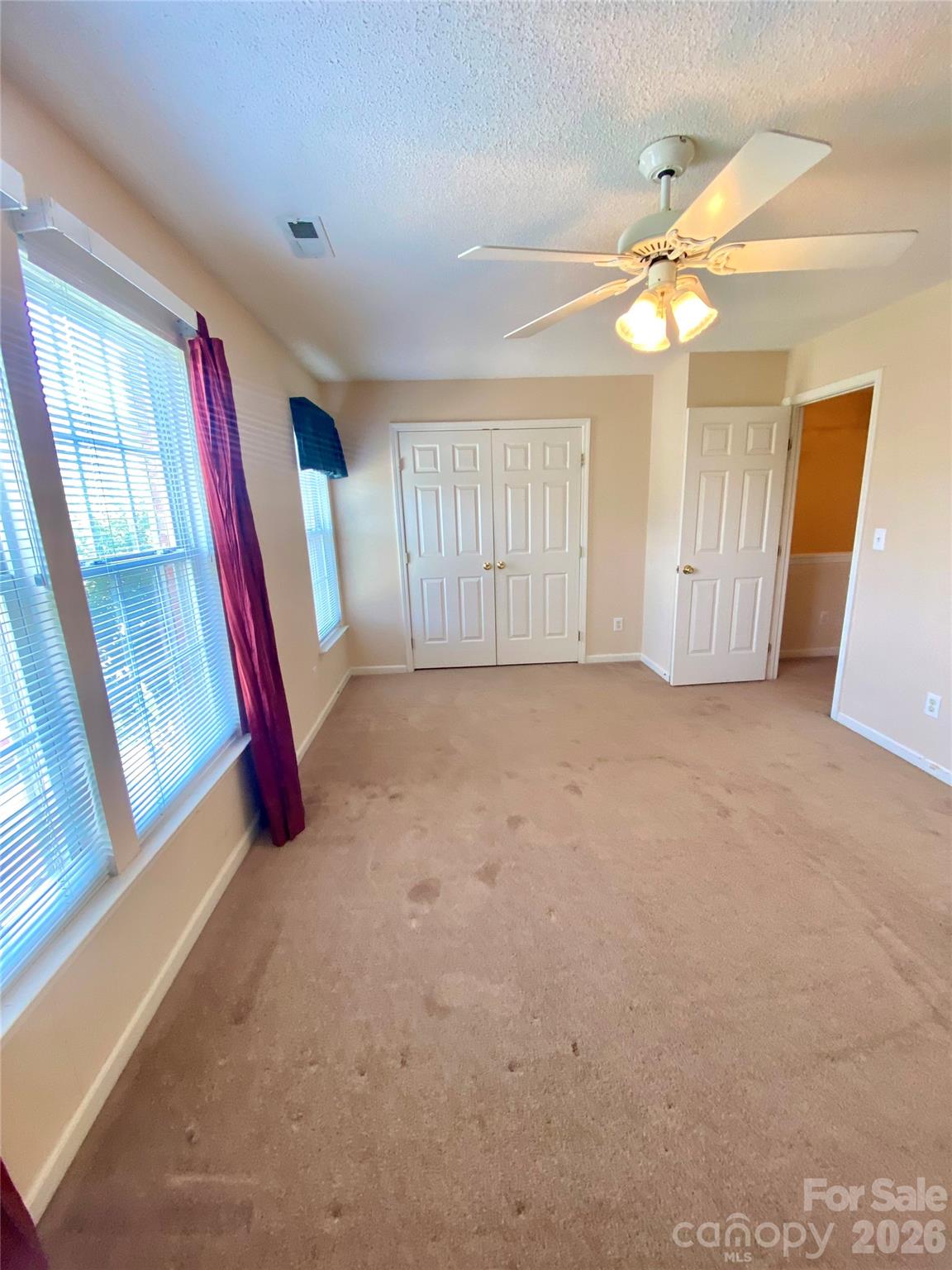 Secondary Bedroom with ceiling light fan, spacious closet, lots of natural lighting from front side of home. - 6025 Creft Circle, Indian Trail