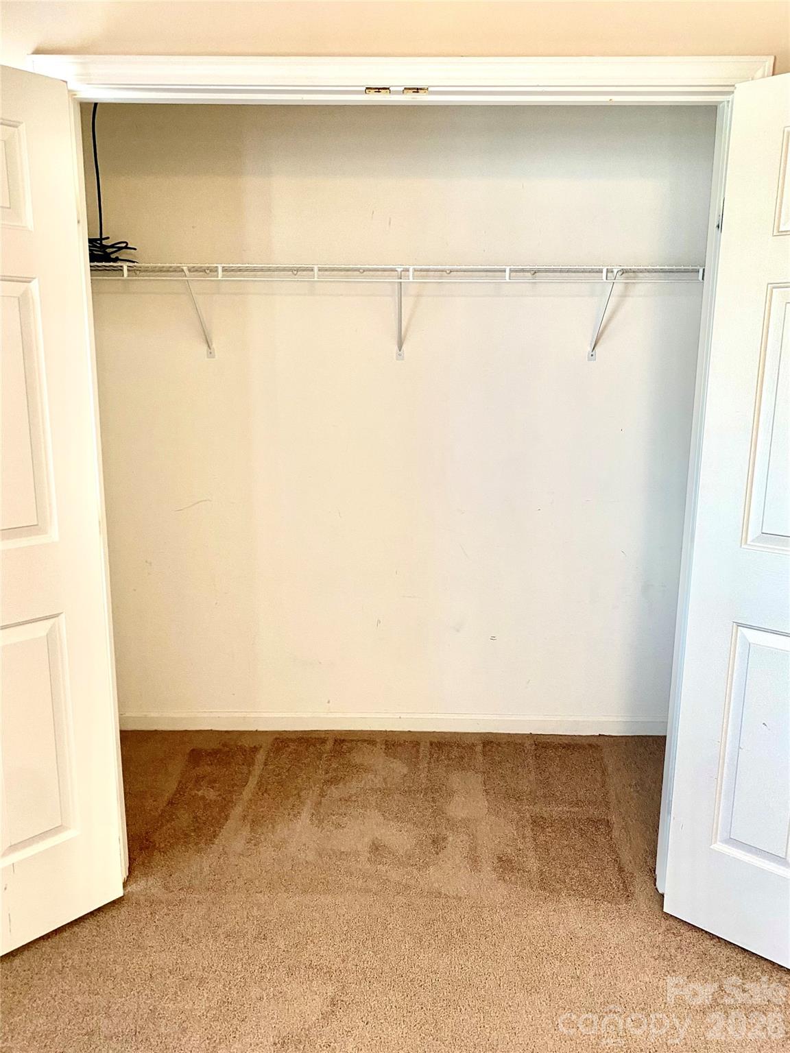 Secondary Bedroom spacious closet with shelves on the right. - 6025 Creft Circle, Indian Trail