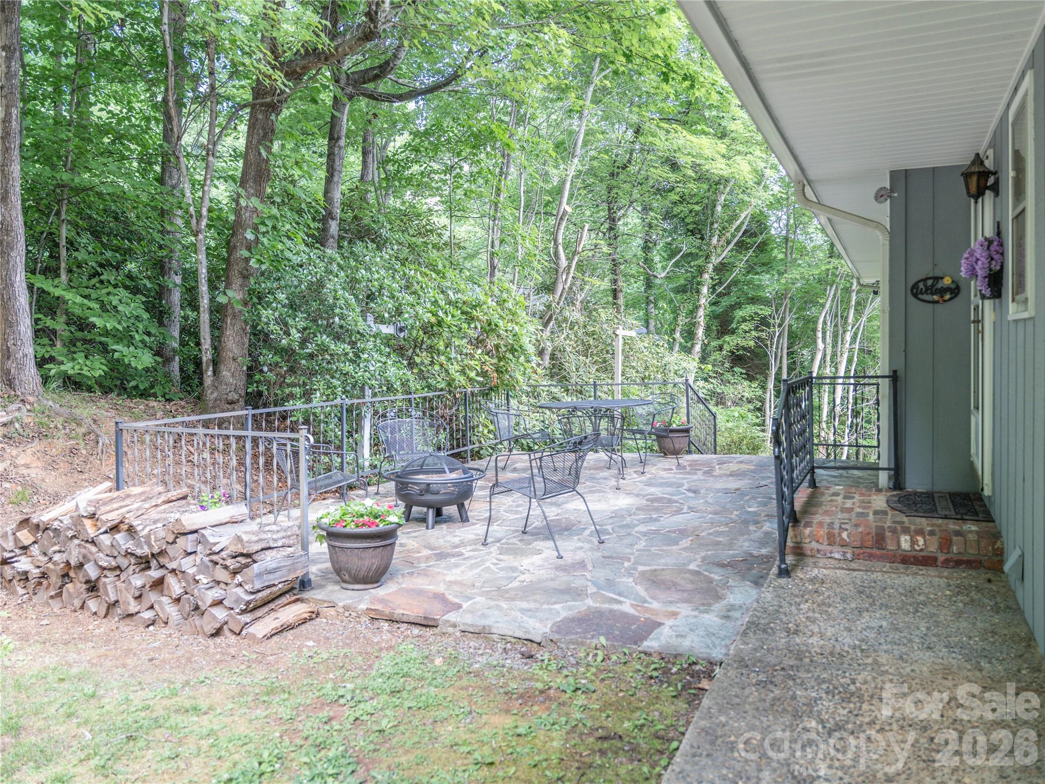 Large patio with firepit and furniture that stays with the home. - 45 Mountain View Avenue, Black Mountain