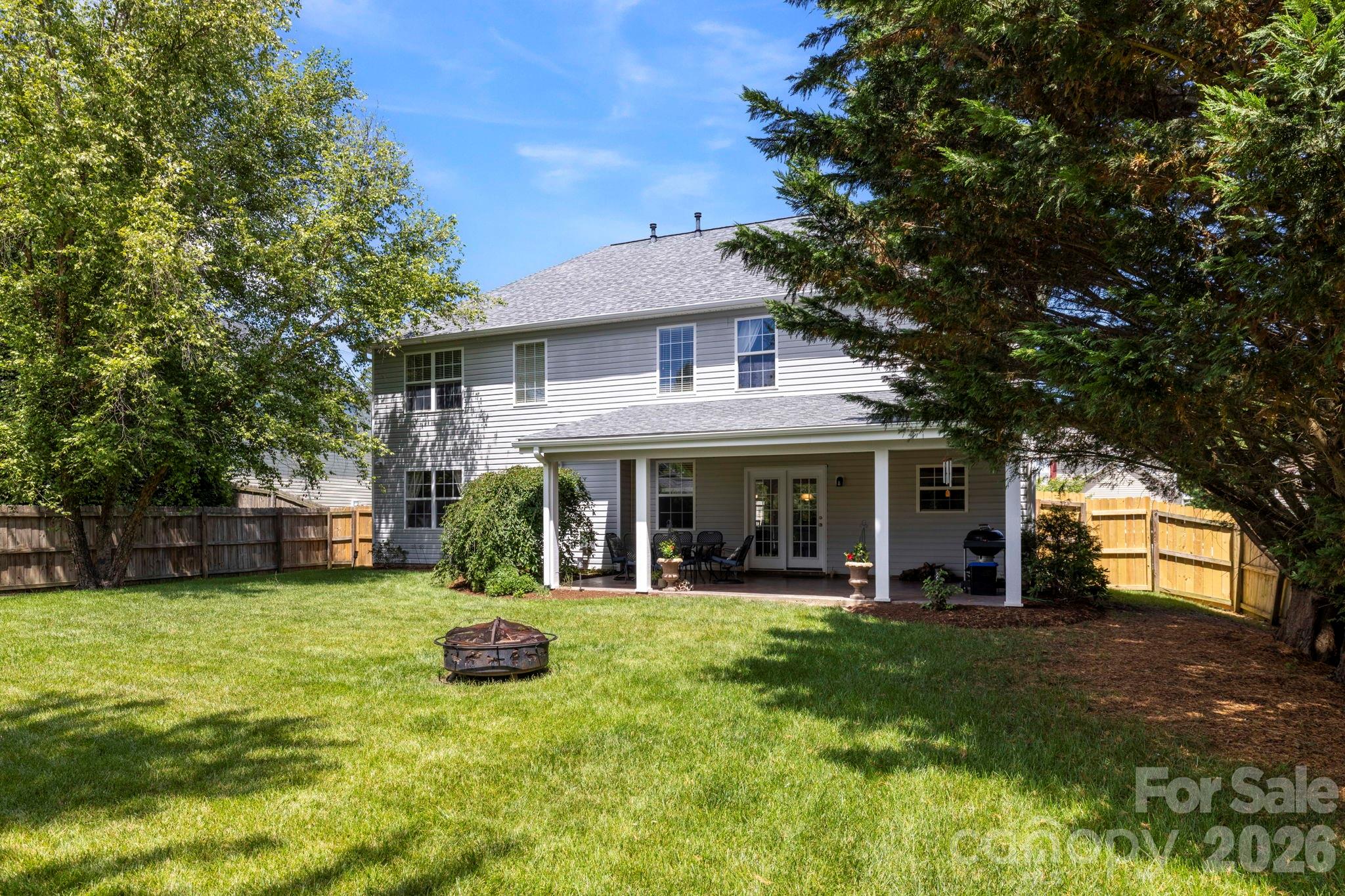 Rear view of the home highlighting the covered outdoor living area and spacious backyard setting. - 266 Wildbriar Road, Fletcher