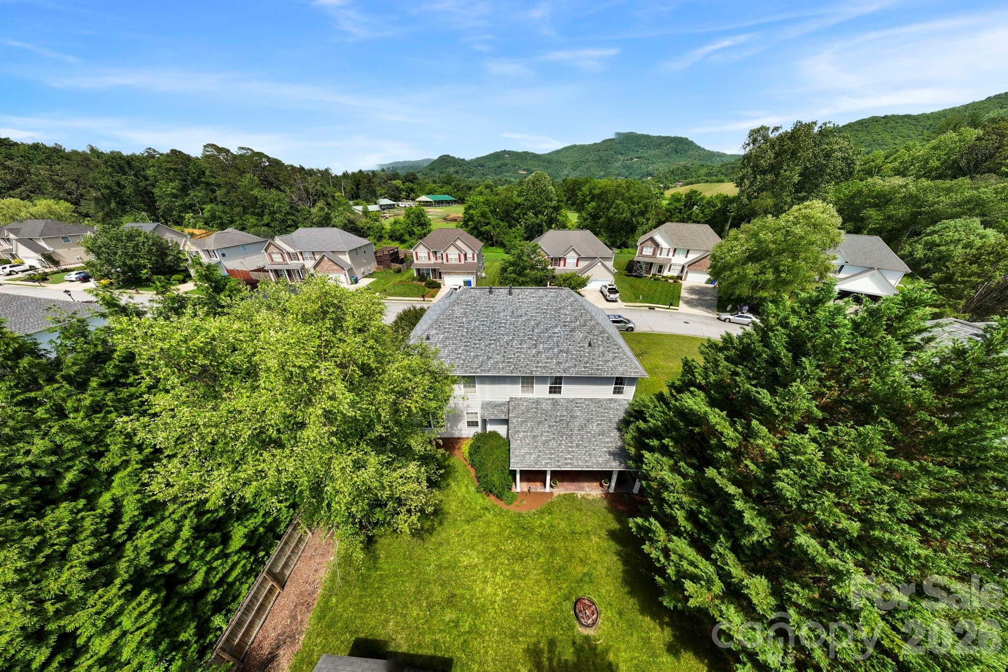 Wide aerial view capturing the neighborhood layout, nearby greenways, and beautiful mountain vistas that define the area. - 266 Wildbriar Road, Fletcher