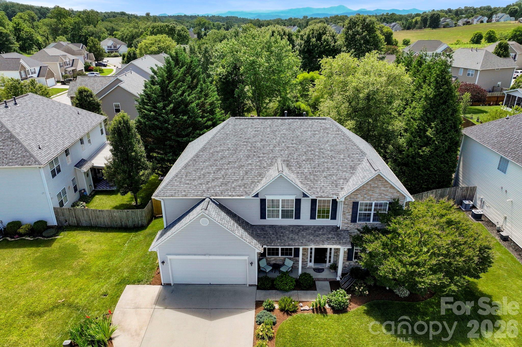 Overhead aerial view showcasing the home's footprint, fenced backyard, outdoor living spaces, and surrounding neighborhood. - 266 Wildbriar Road, Fletcher