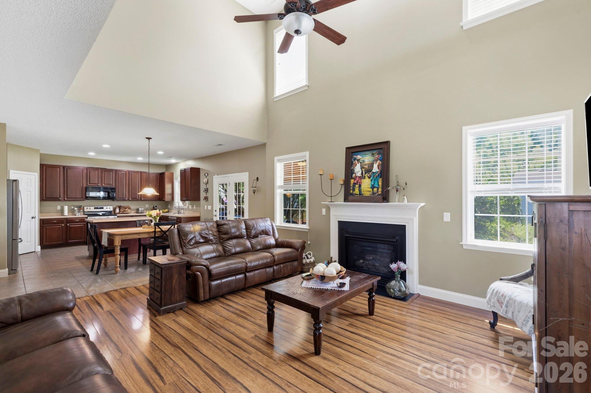 Expansive two-story great room with soaring ceilings, fireplace focal point, and seamless flow into the kitchen and dining areas. - 266 Wildbriar Road, Fletcher