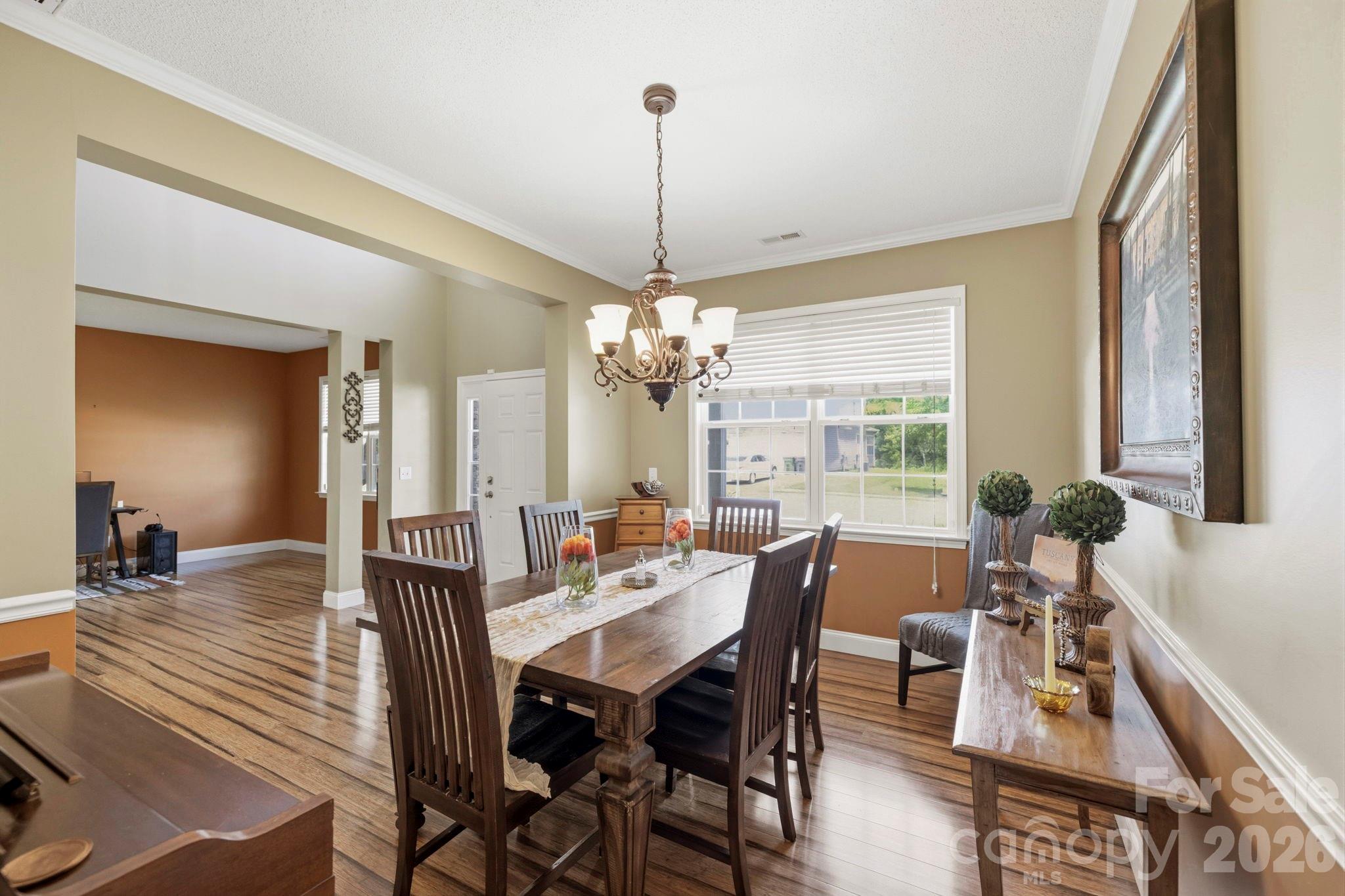 Elegant dining room with crown molding, large windows, and an open connection to the foyer and main living areas. - 266 Wildbriar Road, Fletcher