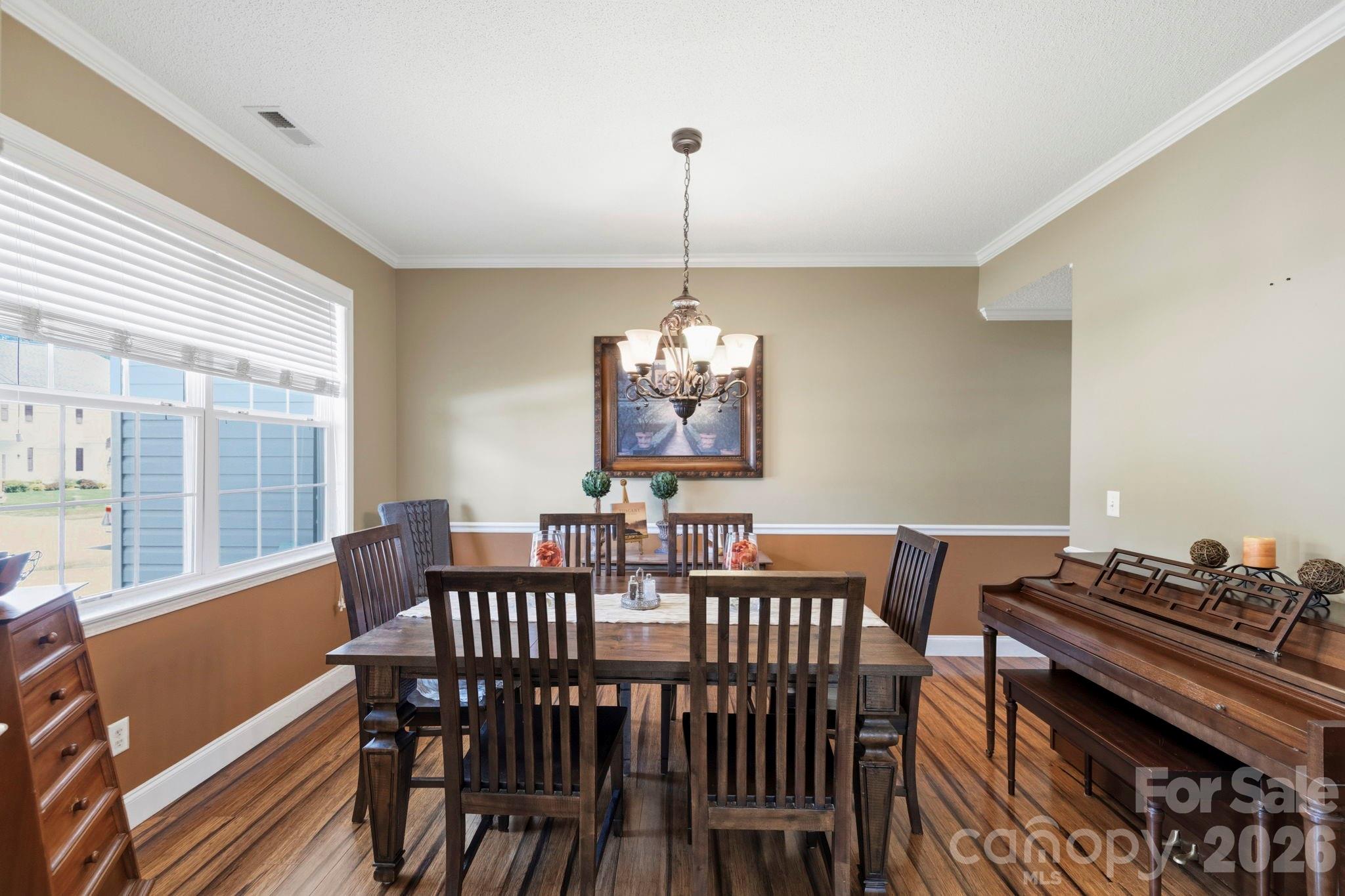 Elegant formal dining room with chair rail detailing, large picture window, and ample space for hosting family gatherings and special occasions. - 266 Wildbriar Road, Fletcher
