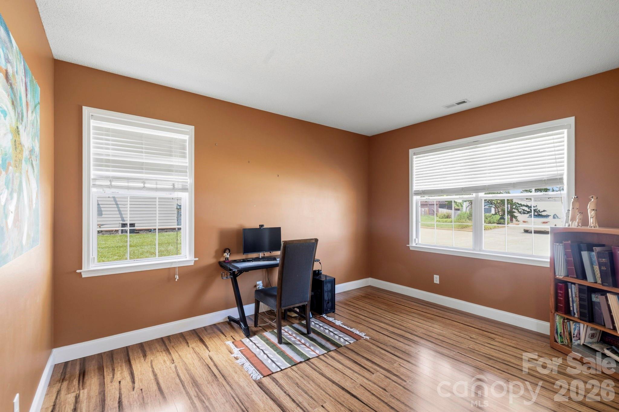 Spacious home office with large windows, natural light, and flexible space for remote work, study, or hobbies. - 266 Wildbriar Road, Fletcher
