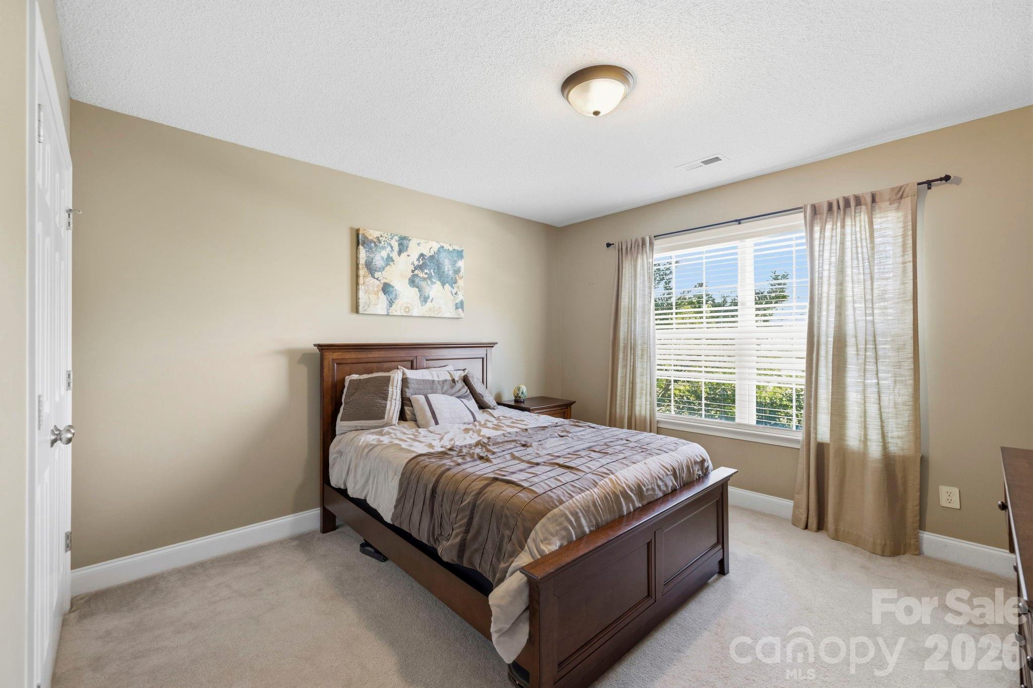 Spacious upper-level bedroom with neutral décor, large window, and comfortable layout for everyday living. - 266 Wildbriar Road, Fletcher