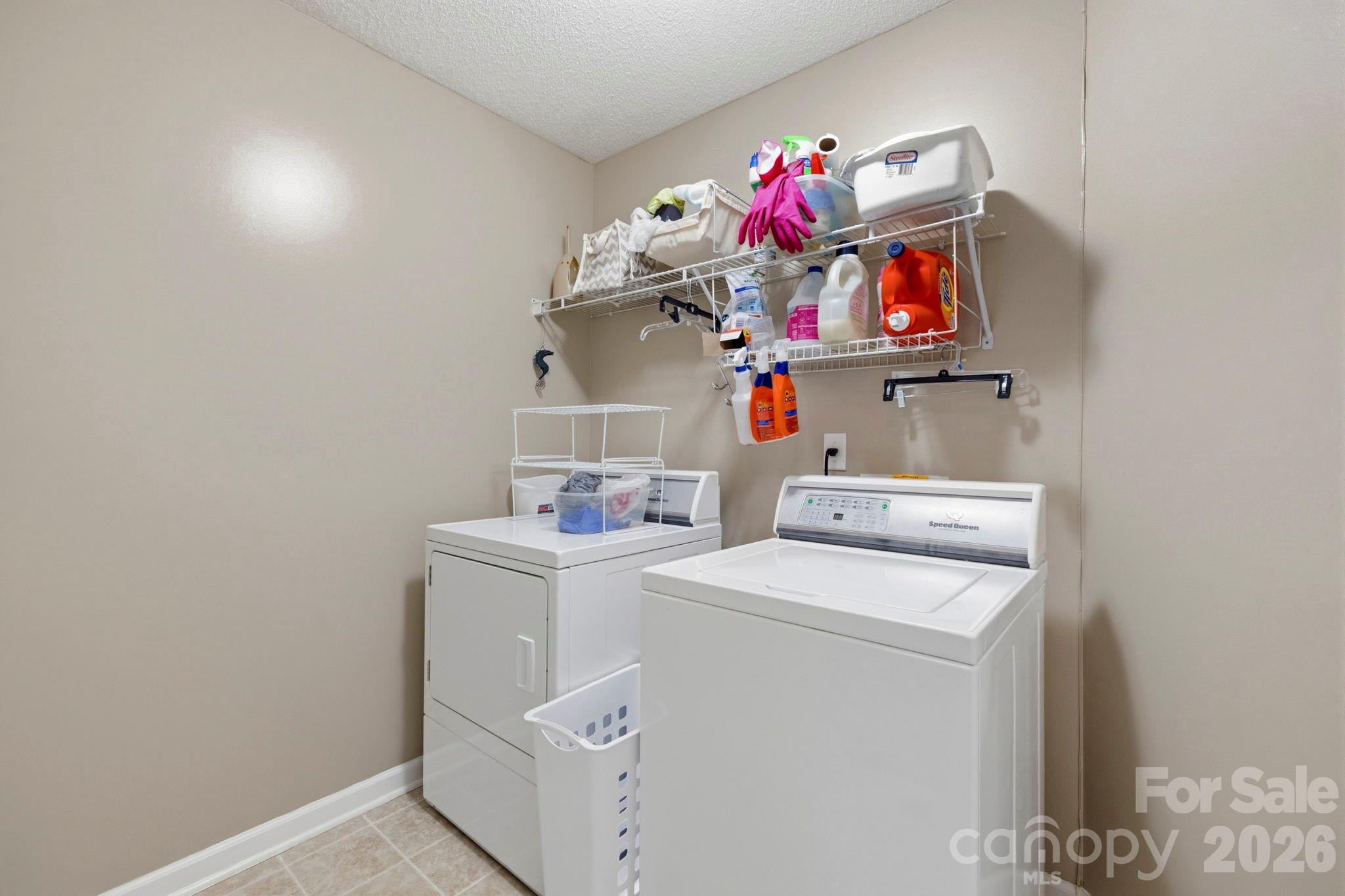 Dedicated laundry room with shelving for storage and organization, providing added convenience for daily household tasks. - 266 Wildbriar Road, Fletcher