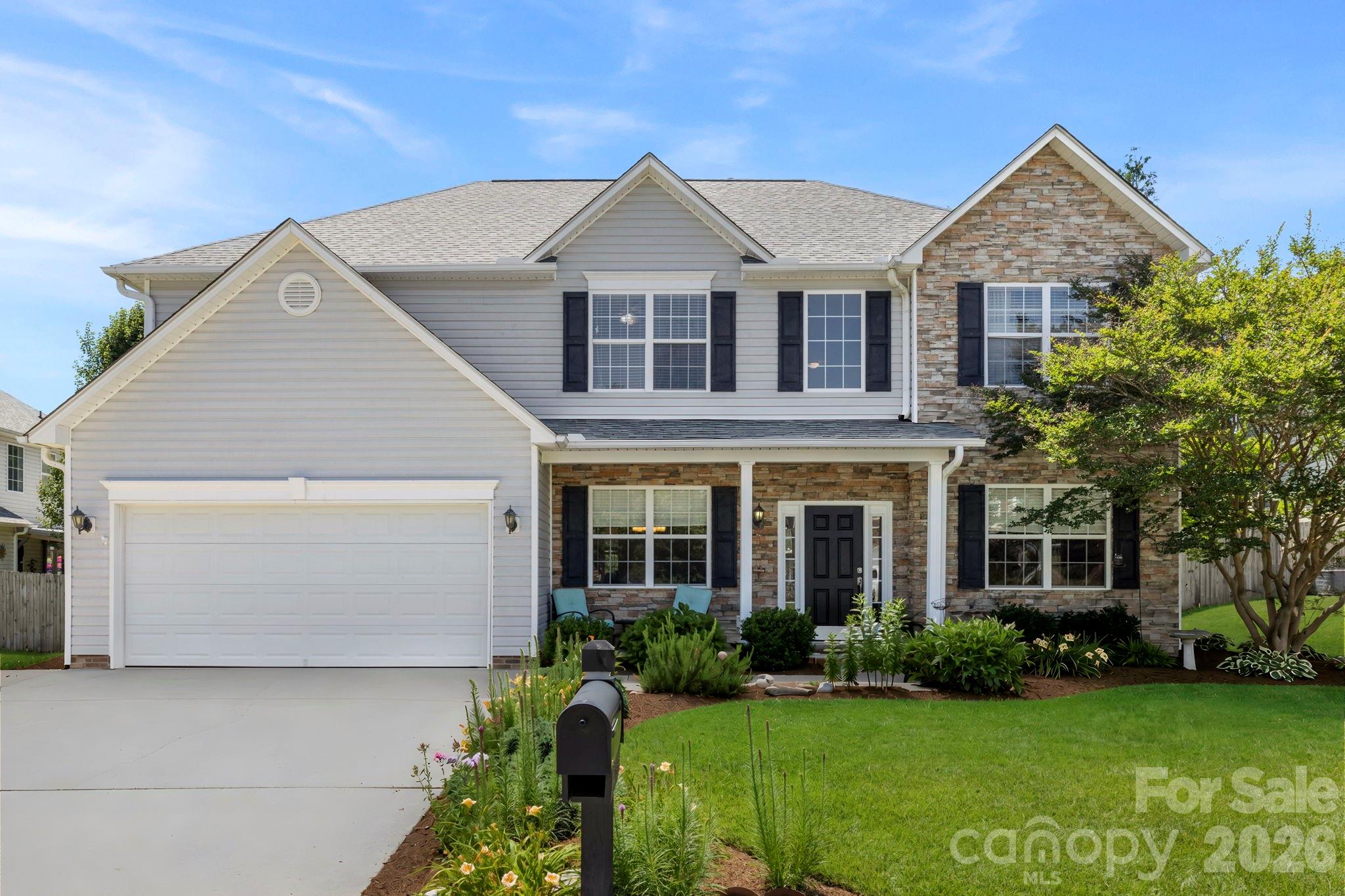 Well-maintained exterior featuring a blend of stone and siding, a covered front porch, and an attractive landscaped yard. - 266 Wildbriar Road, Fletcher