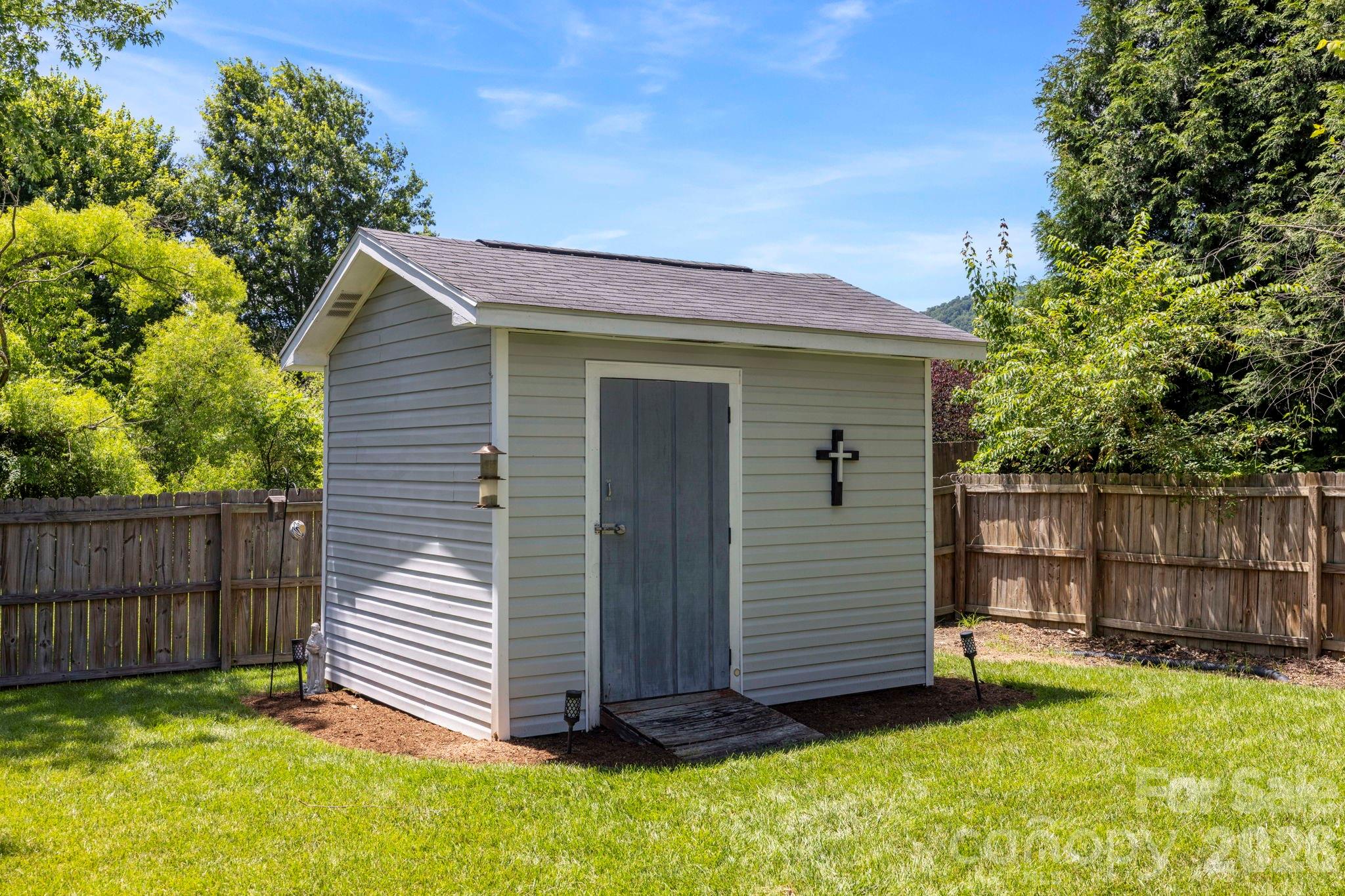 Detached storage building provides additional space for tools, equipment, or seasonal storage needs. - 266 Wildbriar Road, Fletcher