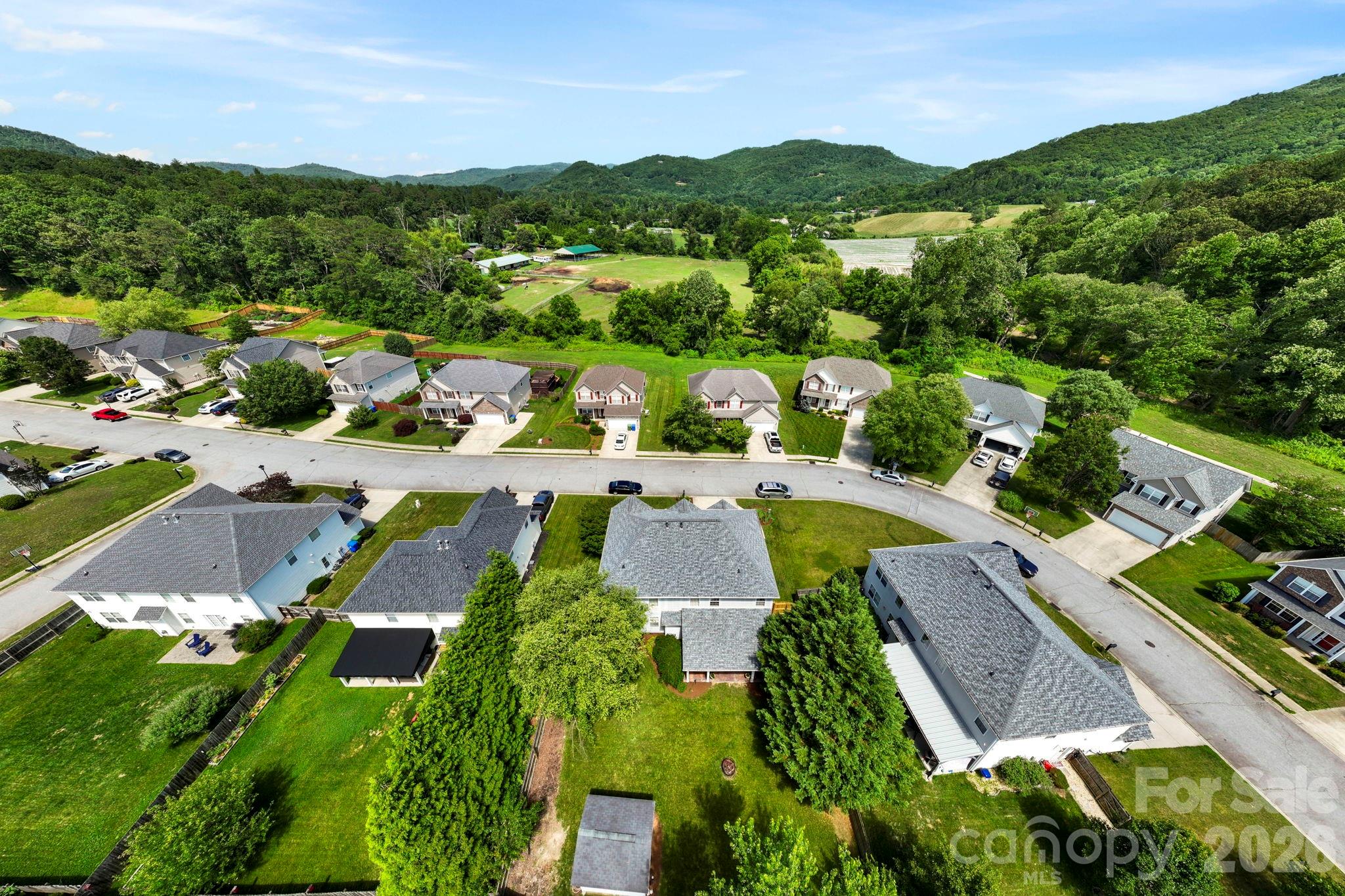 Aerial perspective highlighting the scenic mountain setting, open green spaces, and desirable neighborhood location. - 266 Wildbriar Road, Fletcher