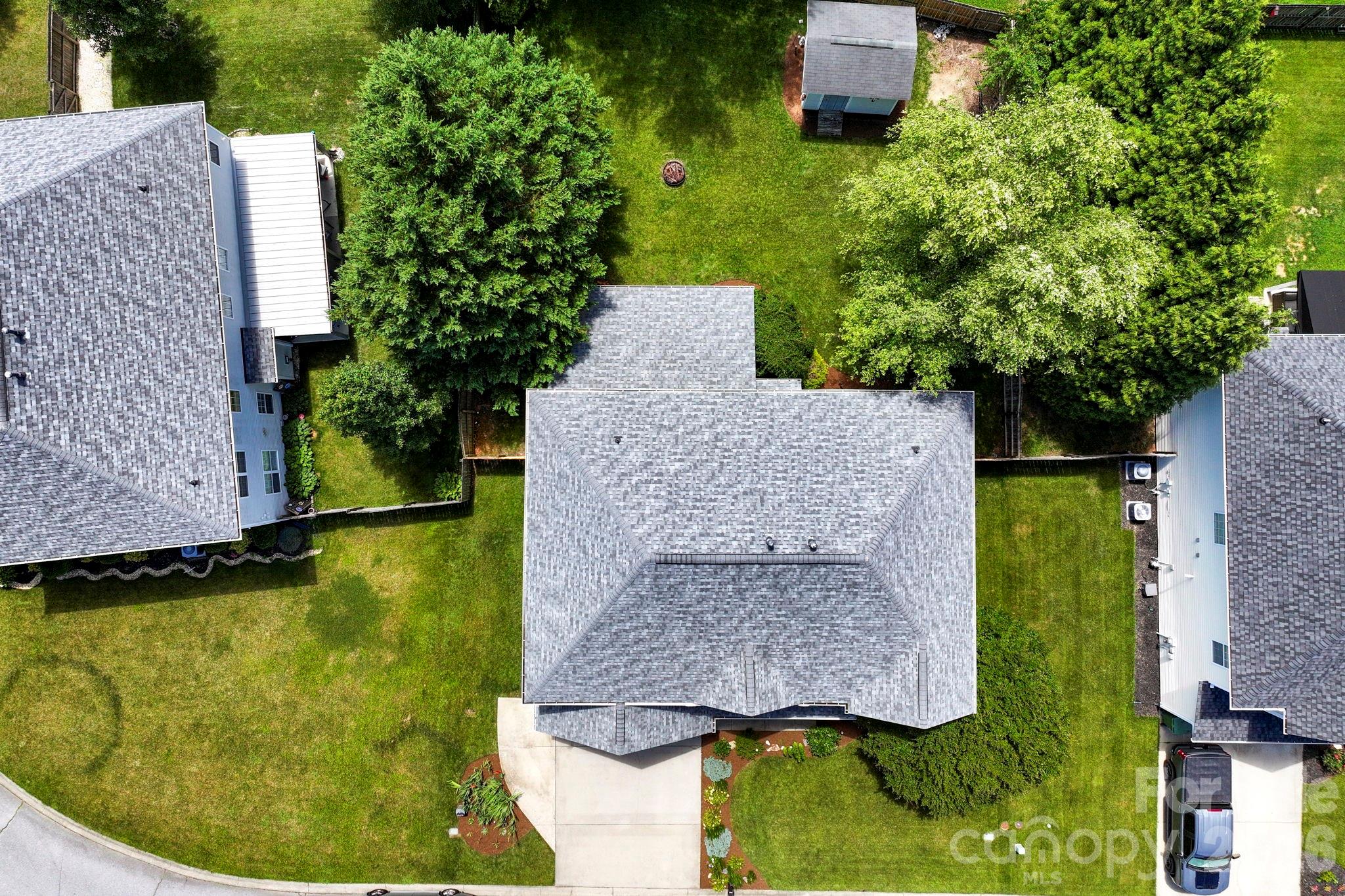 Generous fenced backyard with mature trees, open green space, and a fire pit area for enjoying evenings outdoors. - 266 Wildbriar Road, Fletcher
