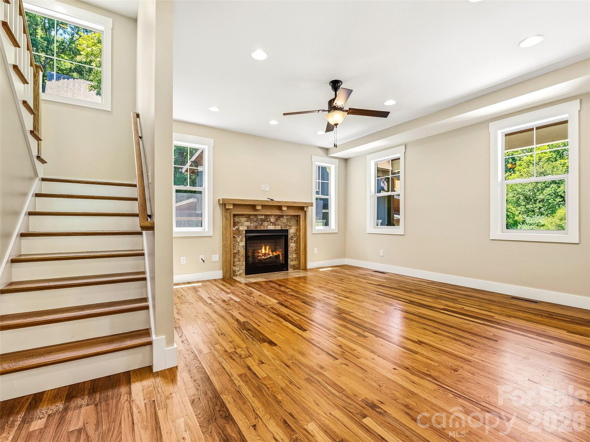 Elegant open staircase leading to the upper levels. - 25 Shady Park Lane, Asheville