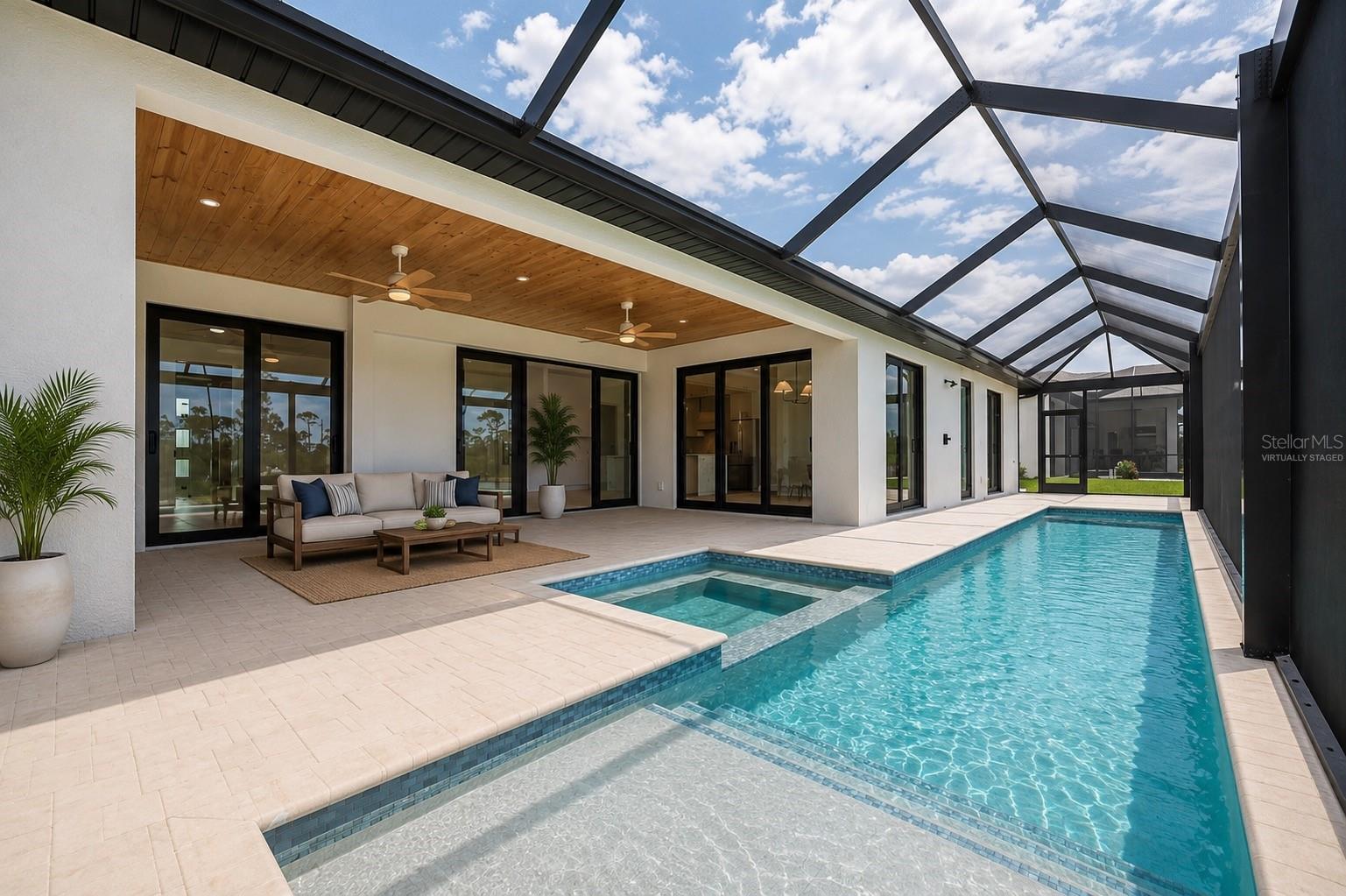 Virtually Staged Patio Showcasing the Resort Style Pool, Spa, and Expansive Covered Outdoor Living Area. - 16692 LIGGETT CIR, PORT CHARLOTTE