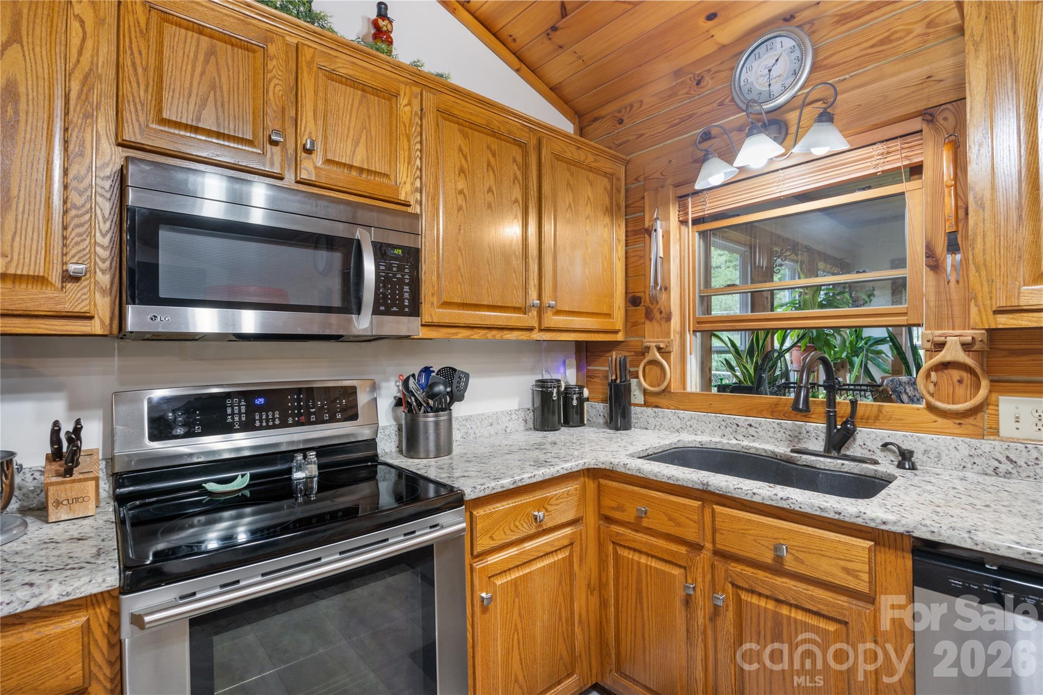 Granite countertops and stainless appliances create a stylish workspace. - 214 Harbor Ridge Drive, Connelly Springs