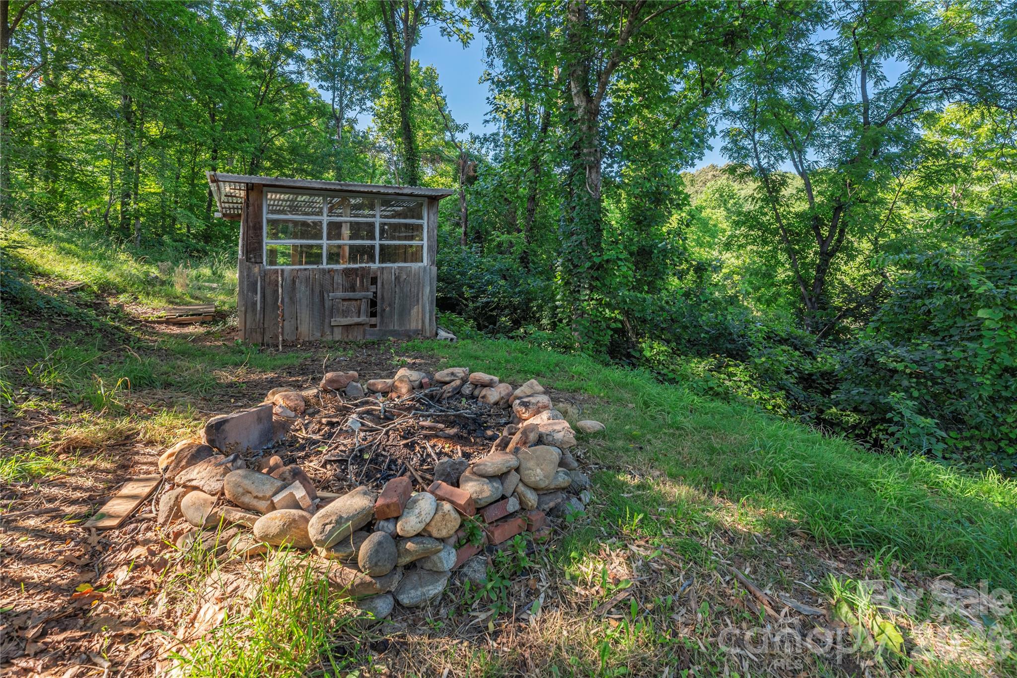 Fire pit area tucked among the trees, perfect for relaxing evenings outdoors. - 261 Star Ridge Road, Canton