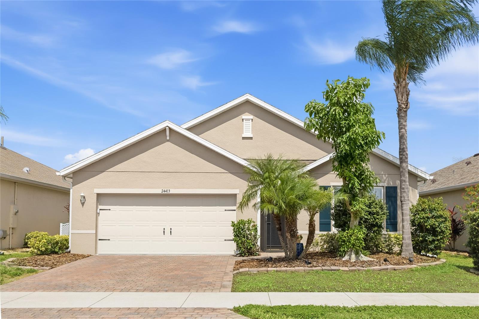 Front of home with Lush Landscaping and screen enclosed foyer. - 24413 BANDONI PL, VENICE