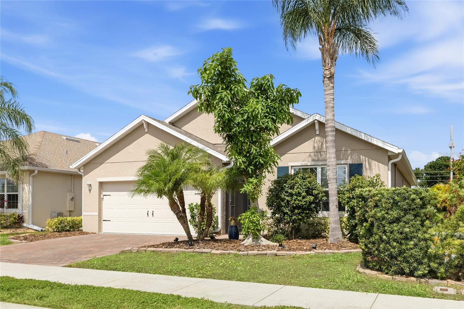 Front of home with Lush Landscaping and screen enclosed foyer. - 24413 BANDONI PL, VENICE