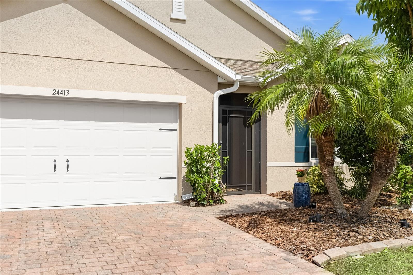 Front of home with Lush Landscaping and screen enclosed foyer. - 24413 BANDONI PL, VENICE
