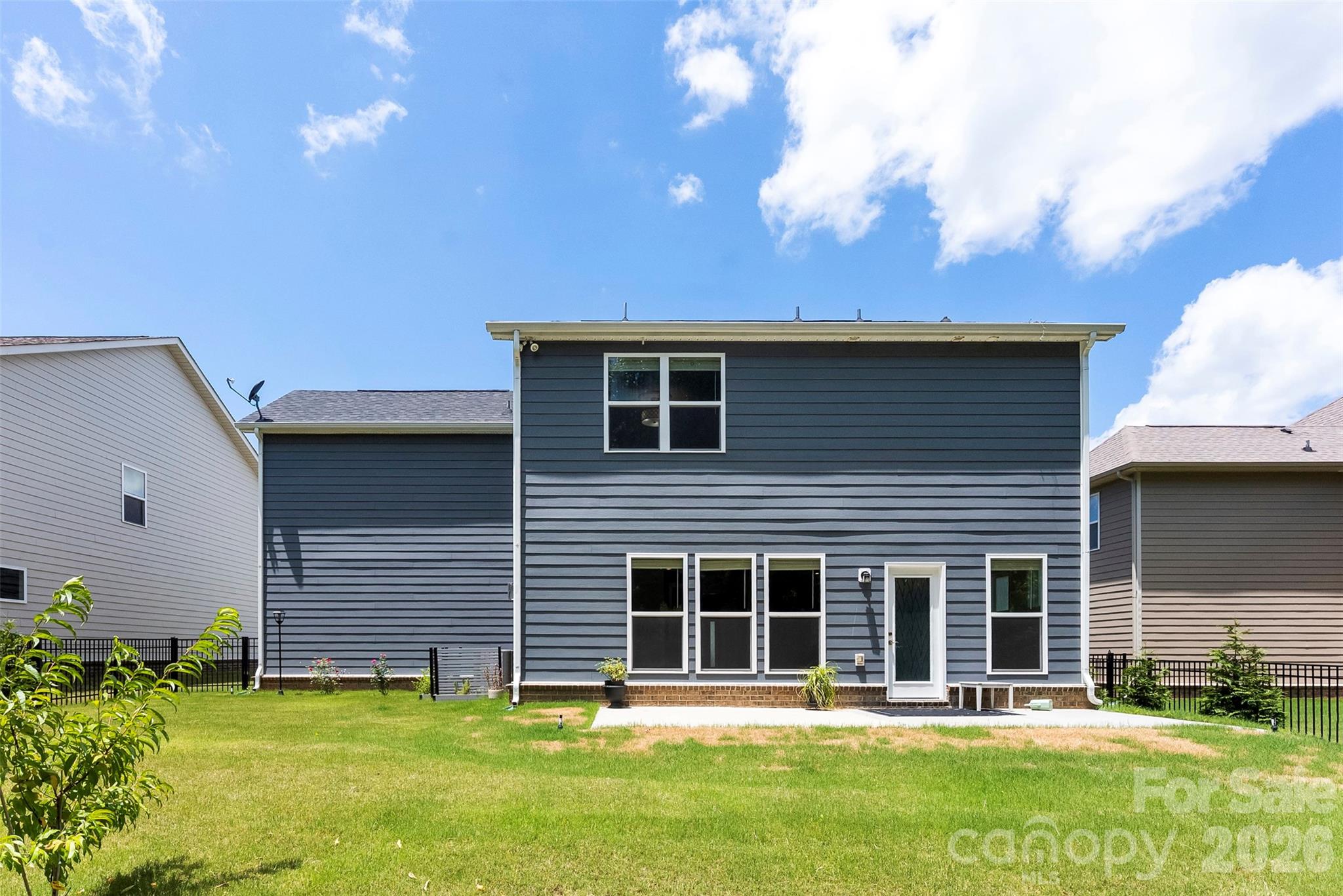 Real of home features patio. Flat backyard. - 1318 Poppy Way, Matthews