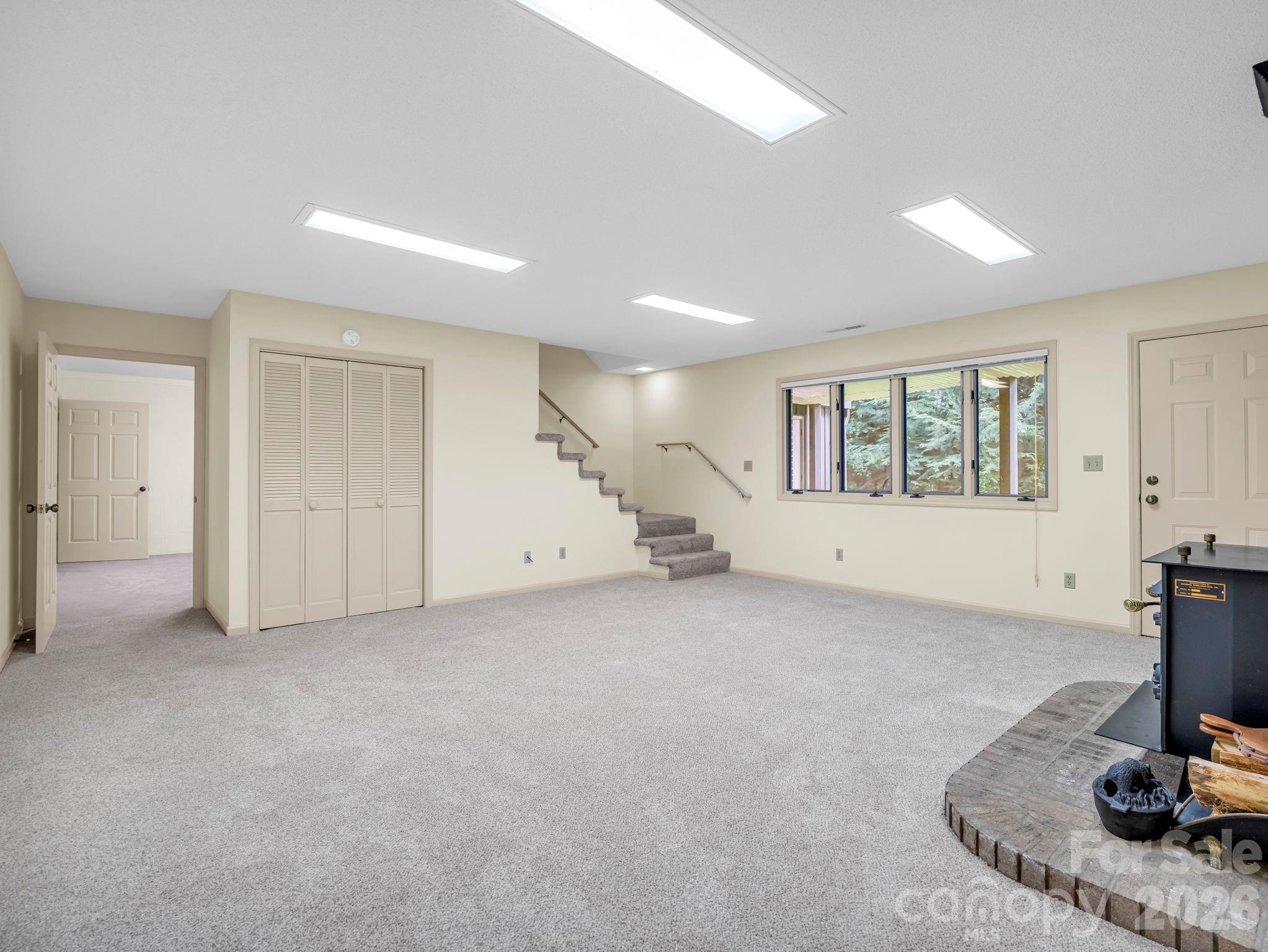 Lower Level family room with wood burning fire place, door leads to fenced backyard - 115 Woodhaven Drive, Hendersonville