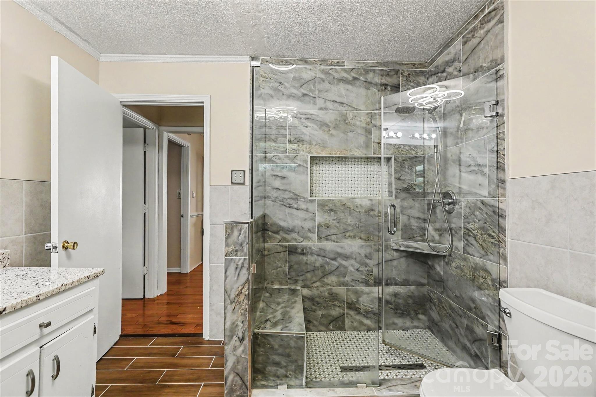 Custom marble tile shower with built-in bench and niche - 1306 Mooresville Road, Kannapolis