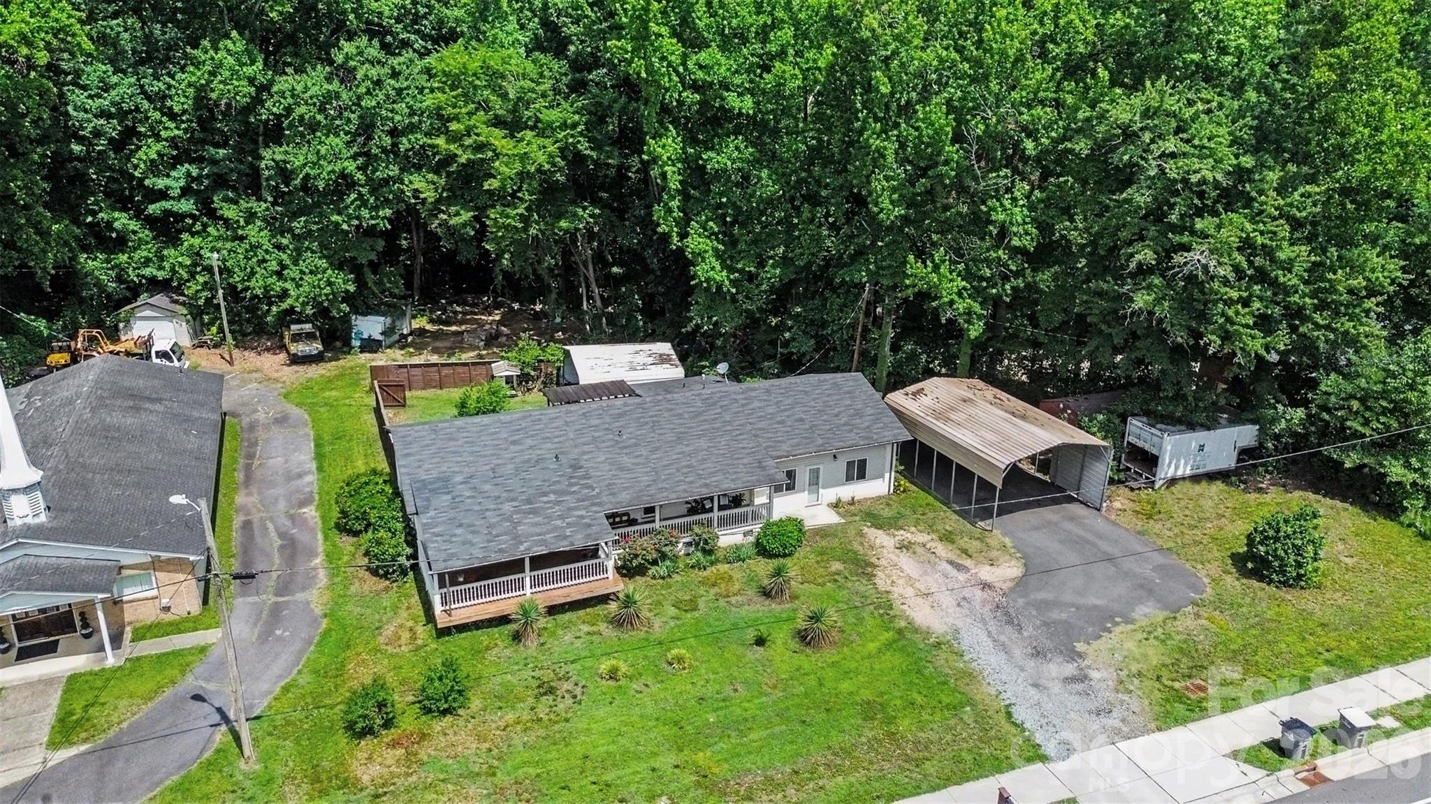 Nearly an acre with a portion of the yard fenced in with a privacy fence and open space beyond - 1306 Mooresville Road, Kannapolis