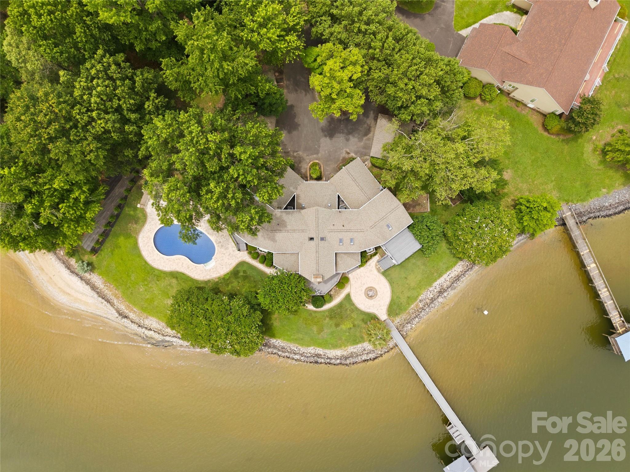 Plenty of privacy and tons of space for outdoor entertaining including 2 covered porches, paver patio, pool, beautiful natural shoreline with hardwood trees, and covered deep water dock w/lift, perfect for quiet lakefront living - 4872 E Liberty Hill Road, York