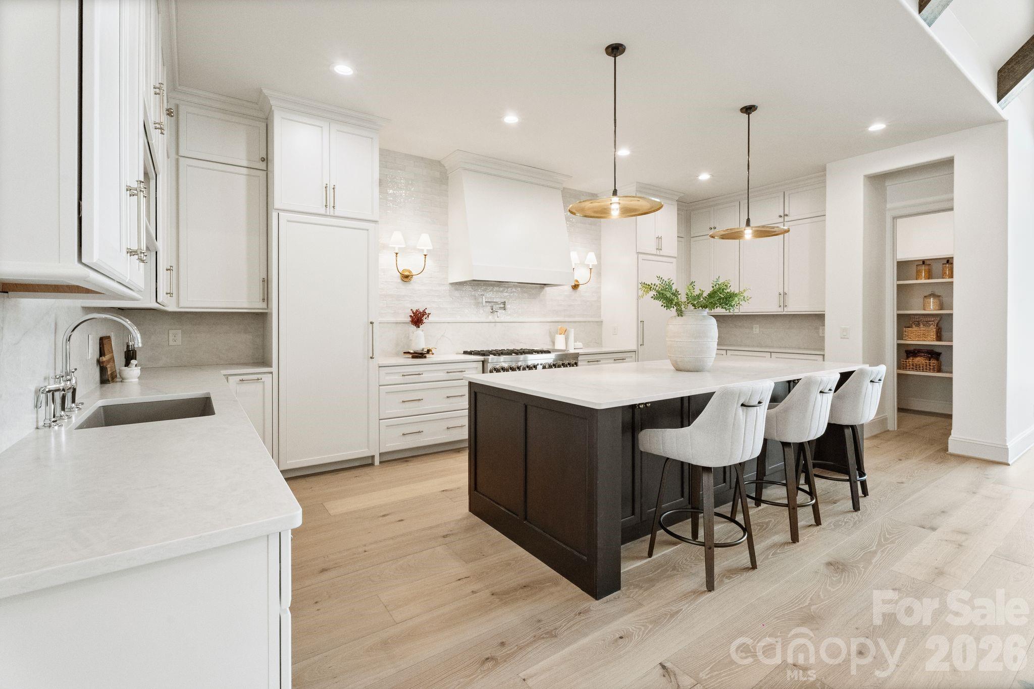 Gourmet kitchen highlighted by quartz counters, spacious island, and huge walk-in pantry - 2494 Primm Road, Denver