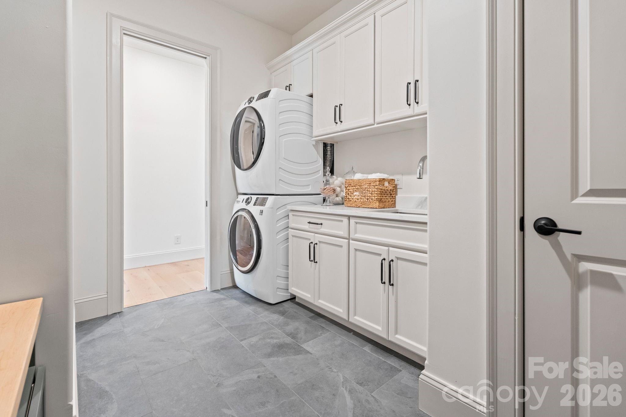 Laundry room includes drop-zone area, cabinets, sink and closet - 2494 Primm Road, Denver