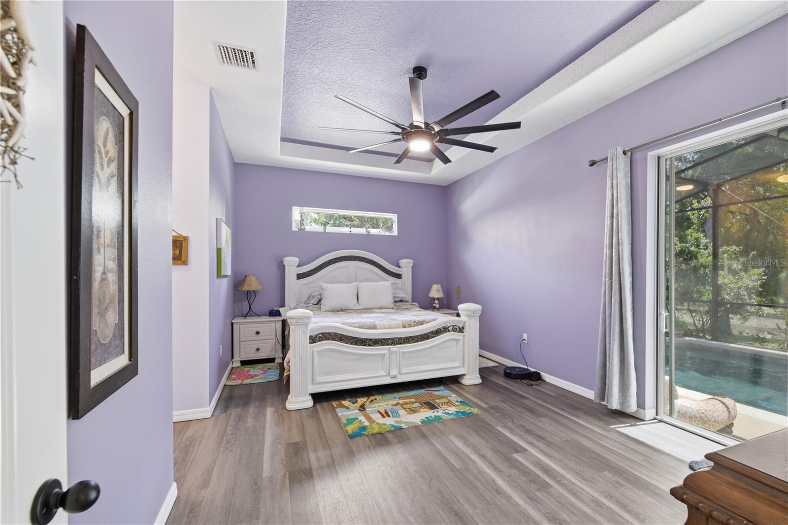 Main bedroom with a tinted sliding door that takes you out to the pool. The window over the bed lets in lots of light. - 225 BIRCHWOOD DR, PALM COAST