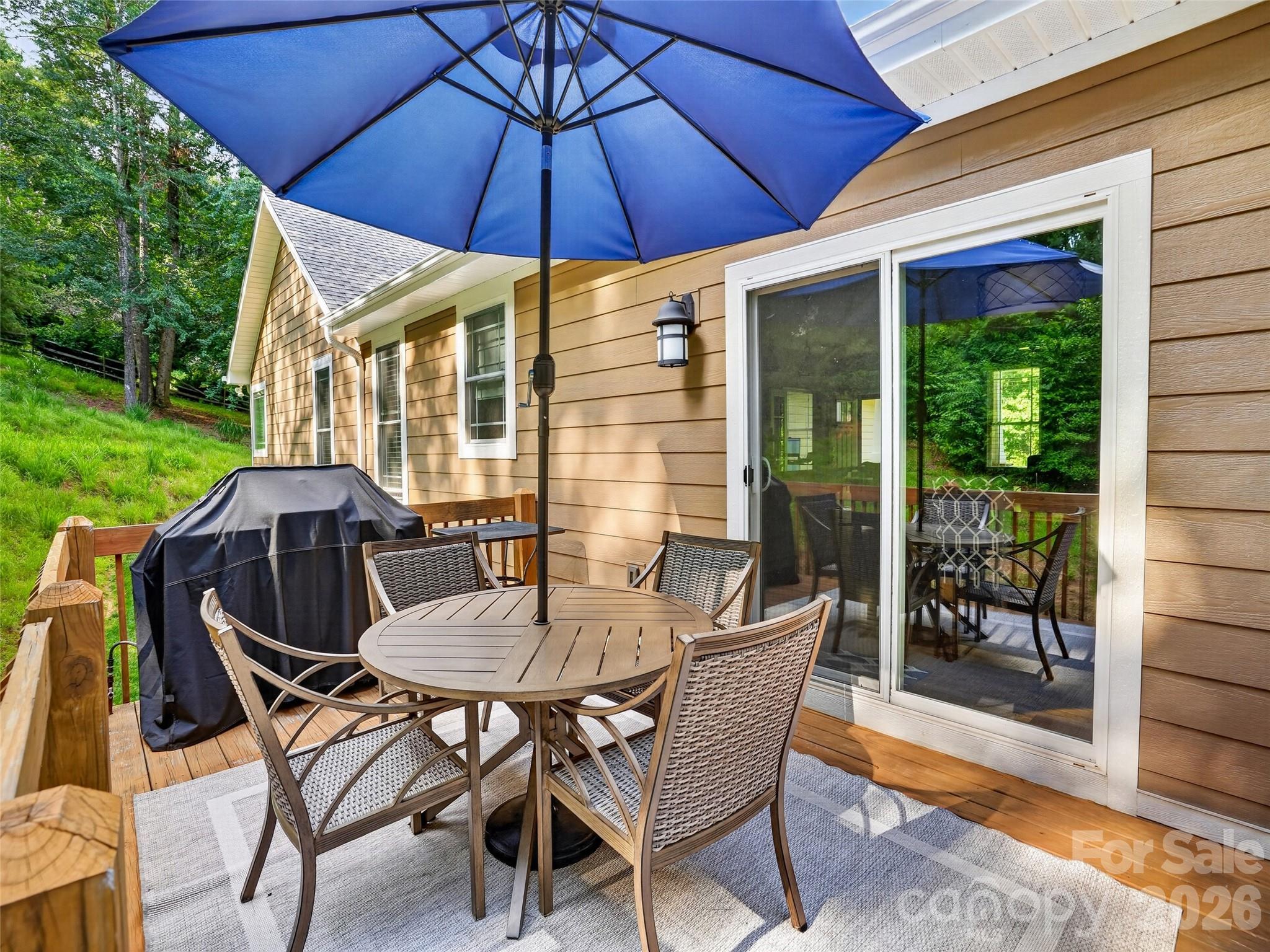 Spacious main-level deck designed for effortless grilling and outdoor entertaining, also a lower sitting area and hot tub to enjoy the surrounding natural setting - 290 Sweetwater Hills Drive, Hendersonville