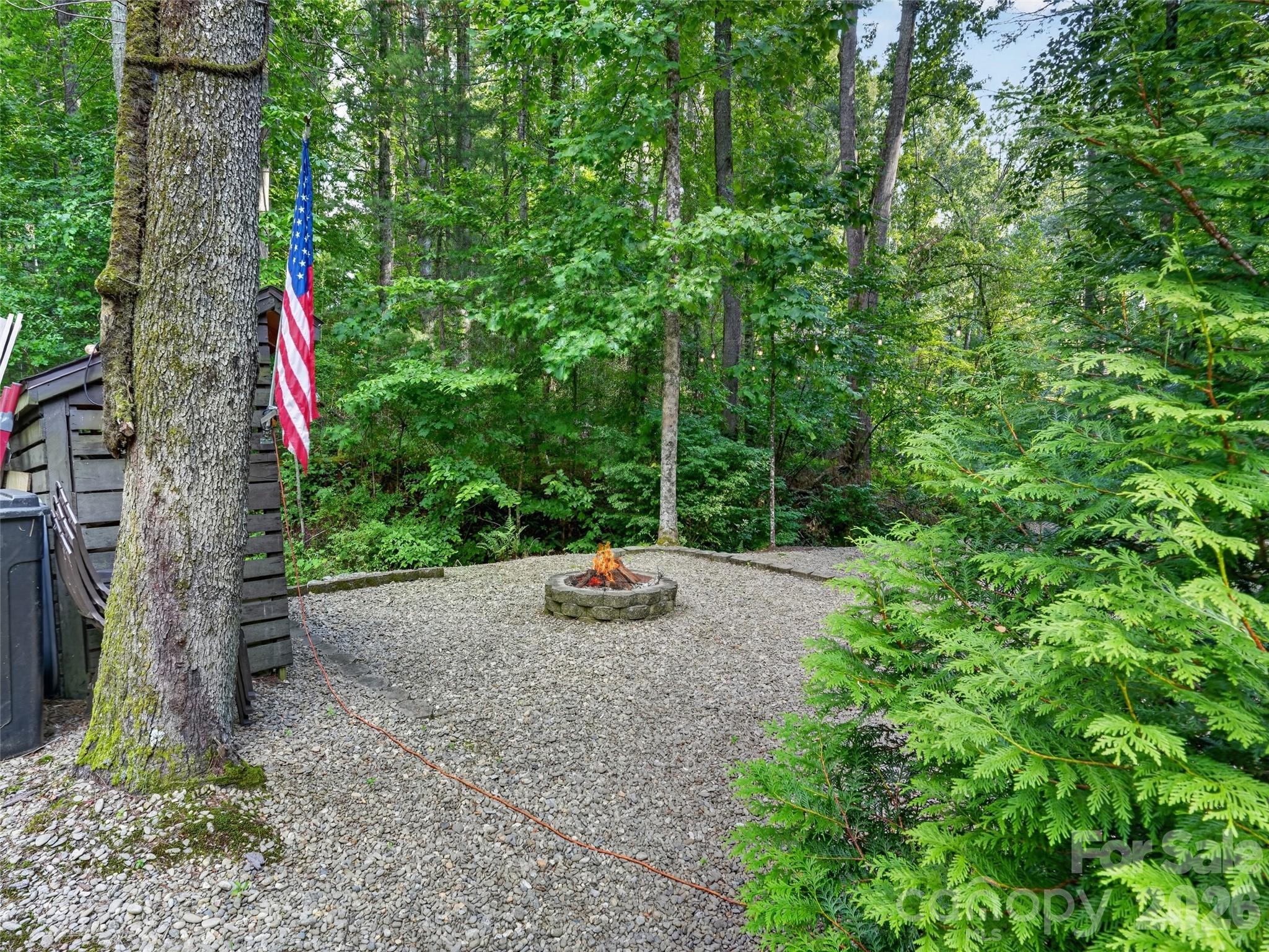 Inviting fire pit retreat nestled among the trees—perfect for cool mountain evenings and relaxed outdoor gatherings - 290 Sweetwater Hills Drive, Hendersonville