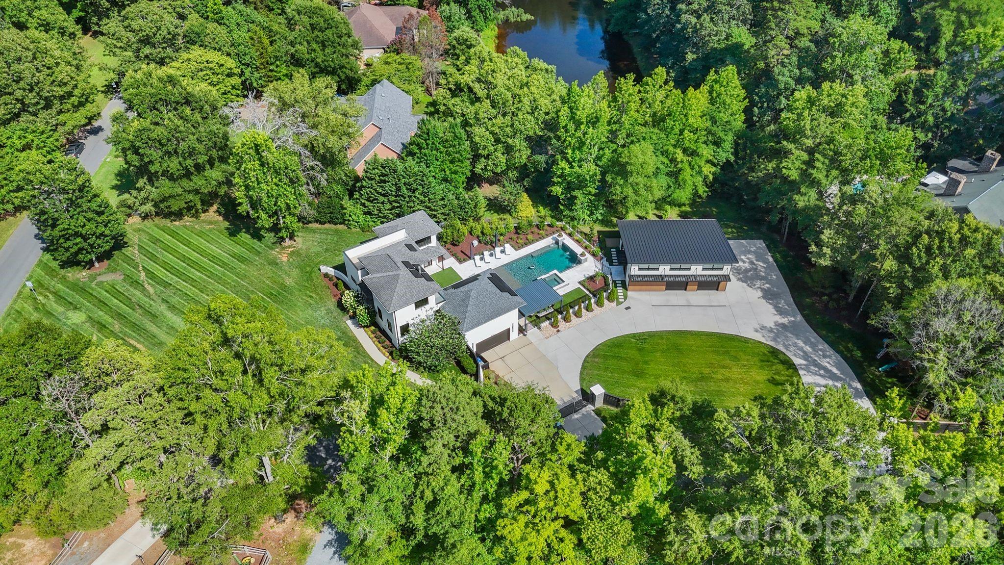 Aerial view of luxury 1.58-acre estate property with private gated grounds and mature landscaping - 1064 Greylyn Drive, Matthews