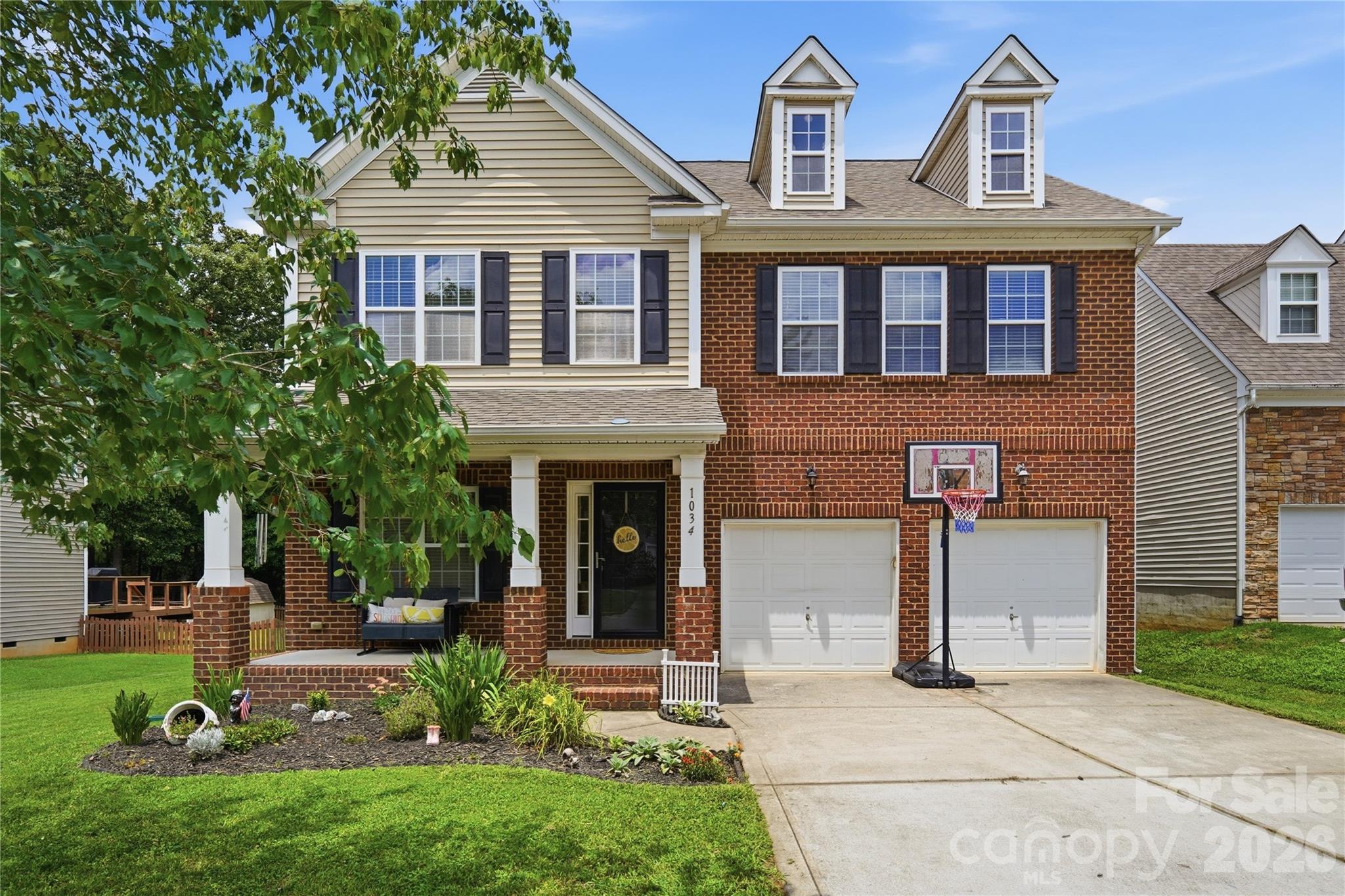 Classic brick-front curb appeal with a welcoming covered porch - 1034 Canopy Drive, Indian Trail