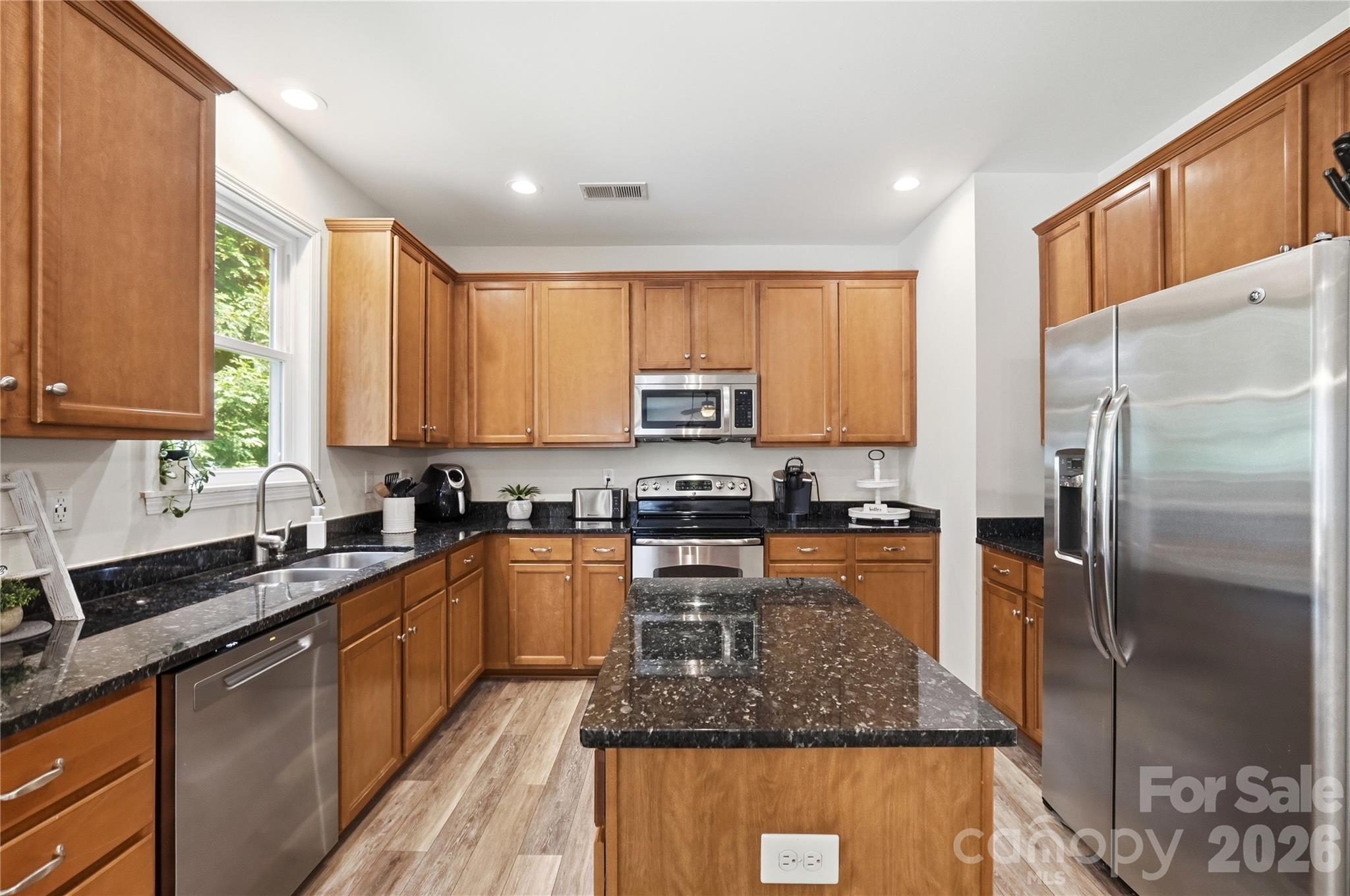 Warm wood cabinetry and stainless steel appliances - 1034 Canopy Drive, Indian Trail