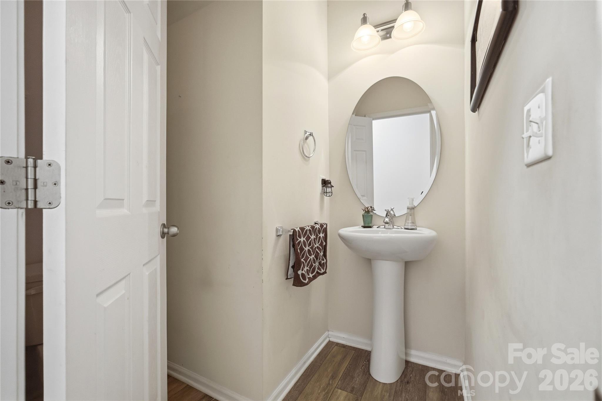 Convenient powder room with a stylish pedestal sink - 1034 Canopy Drive, Indian Trail