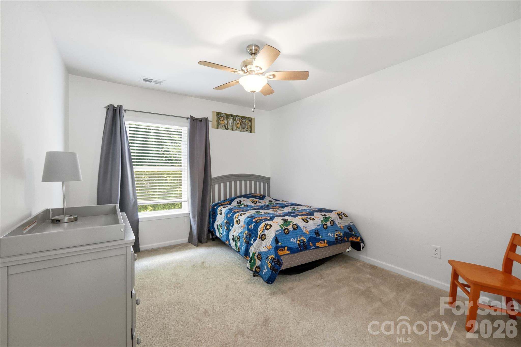 Comfortable guest bedroom with cozy carpet and a bright window - 1034 Canopy Drive, Indian Trail