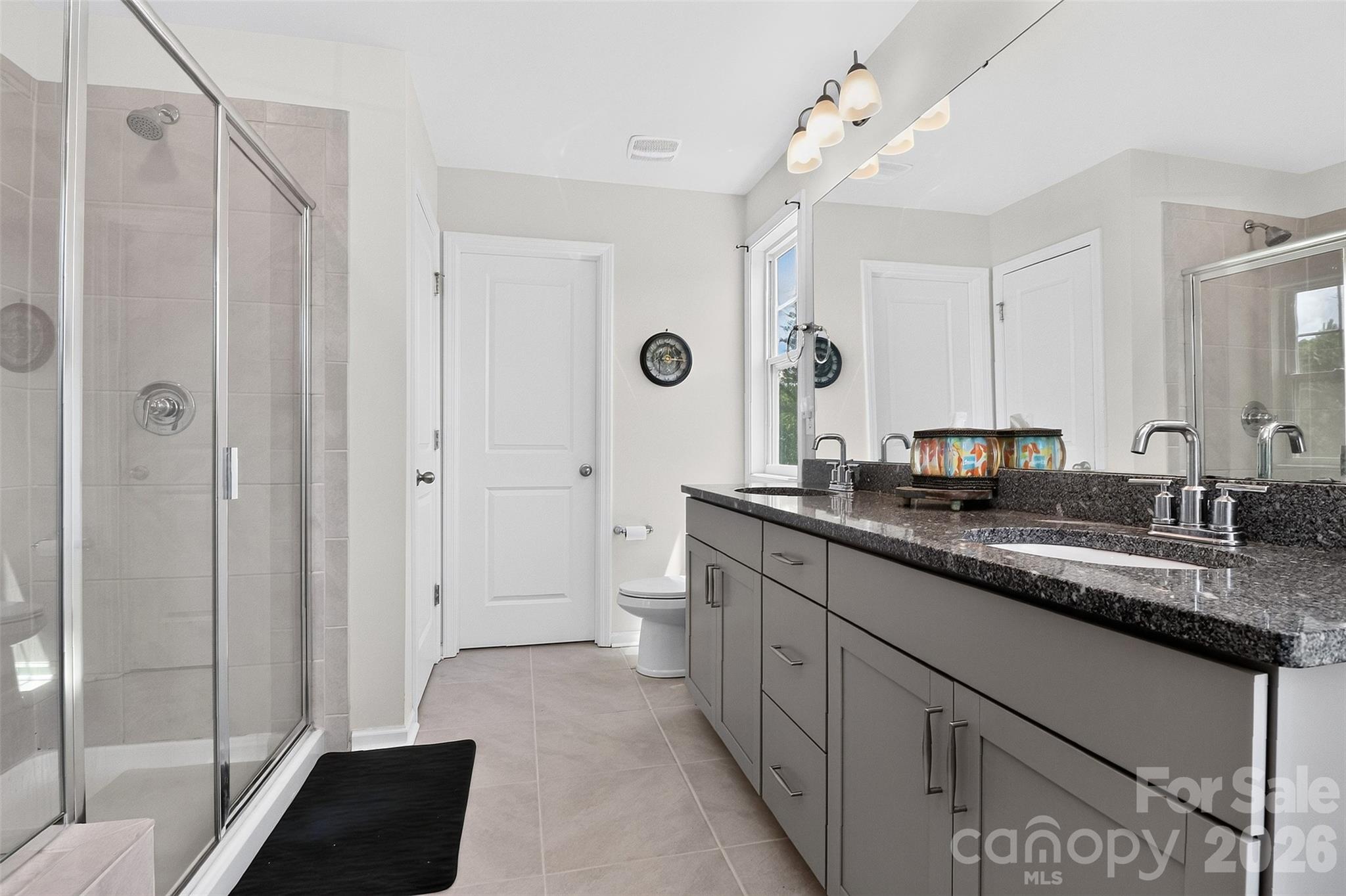 Modern primary bath with dual vanities, linen closet and walk-in closet - 1019 Chicory Trace, Clover
