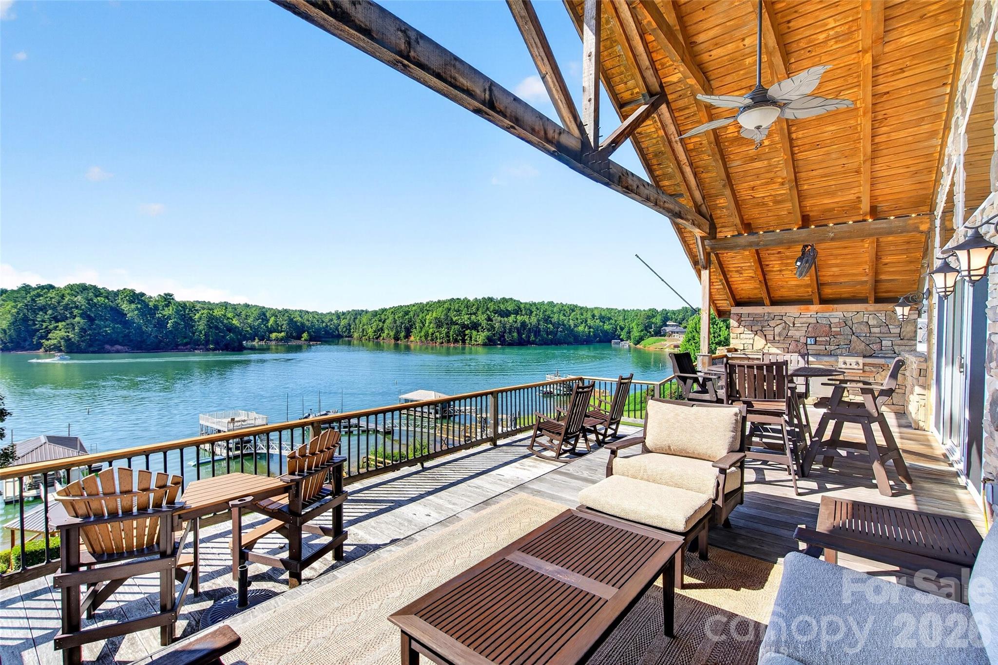 Covered lake-side deck with dining seating, tongue-and-groove wood ceiling, and open view across Lake James. - 831 Lake Club Drive, Nebo