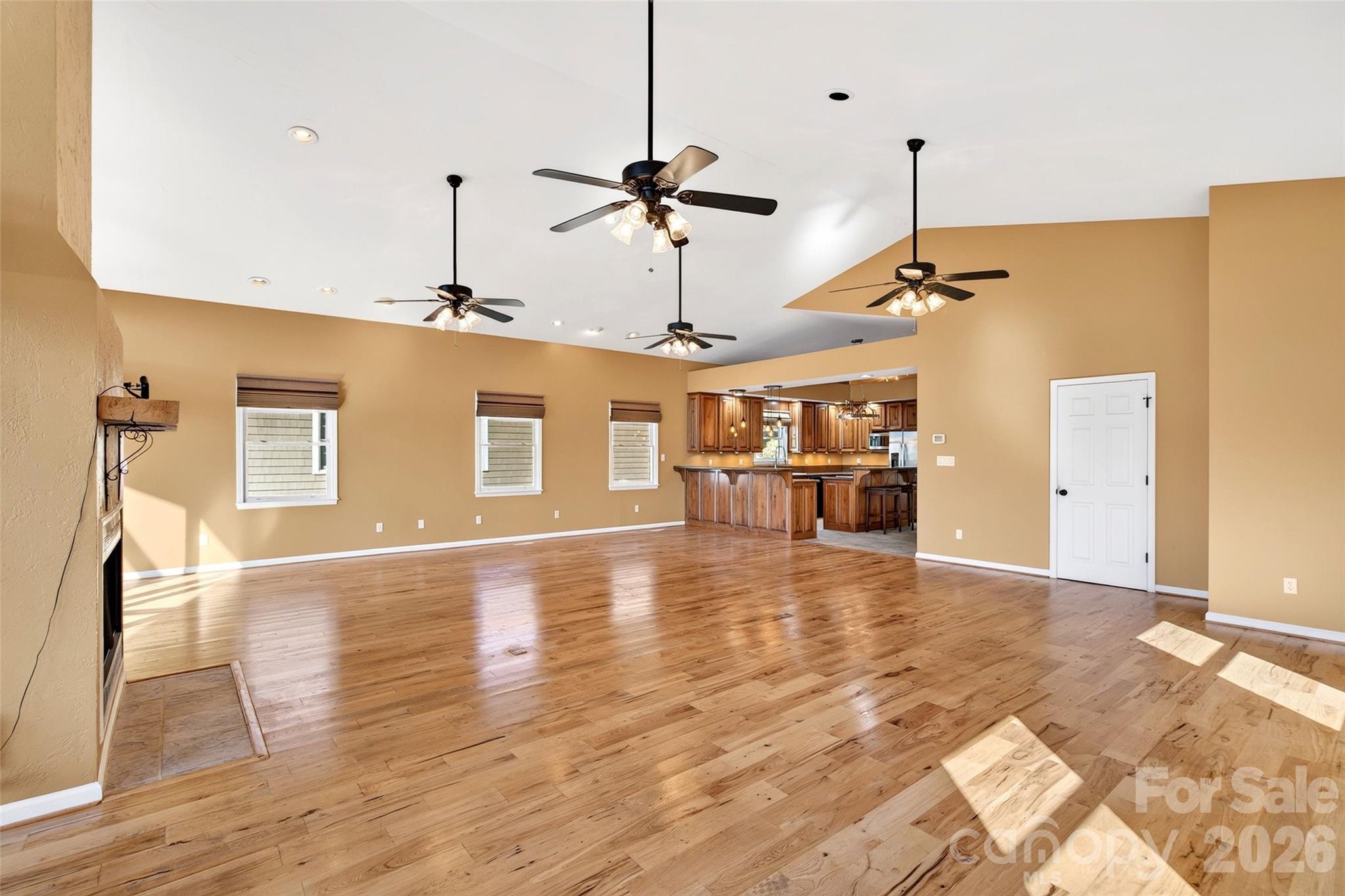 Open main-level living and dining area with hickory hardwood floors and lake-facing windows. - 831 Lake Club Drive, Nebo