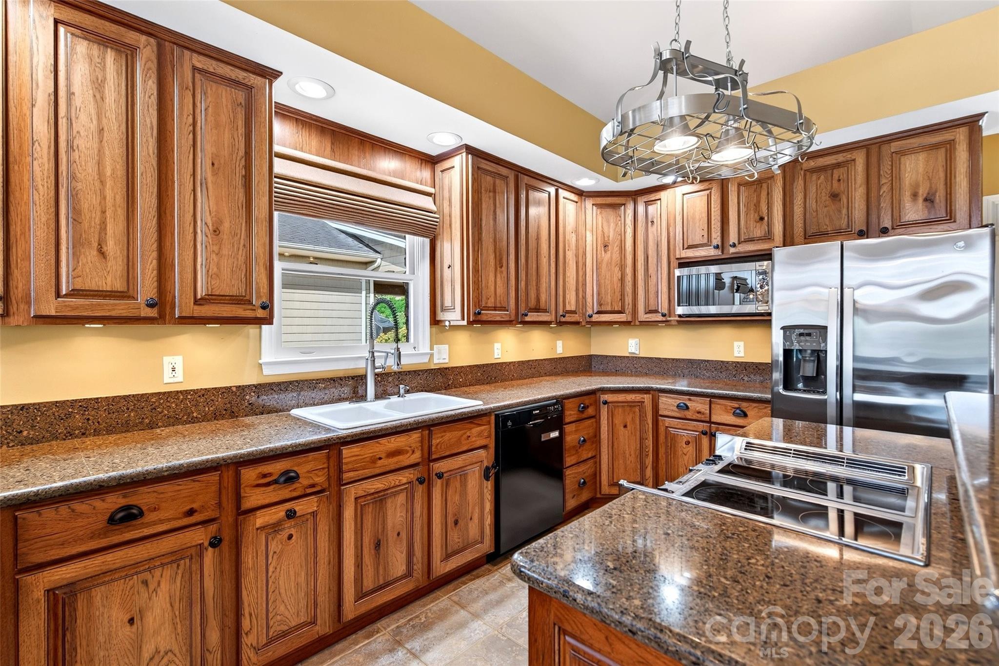 Kitchen range wall and sink with pendant lighting over quartz counters. - 831 Lake Club Drive, Nebo