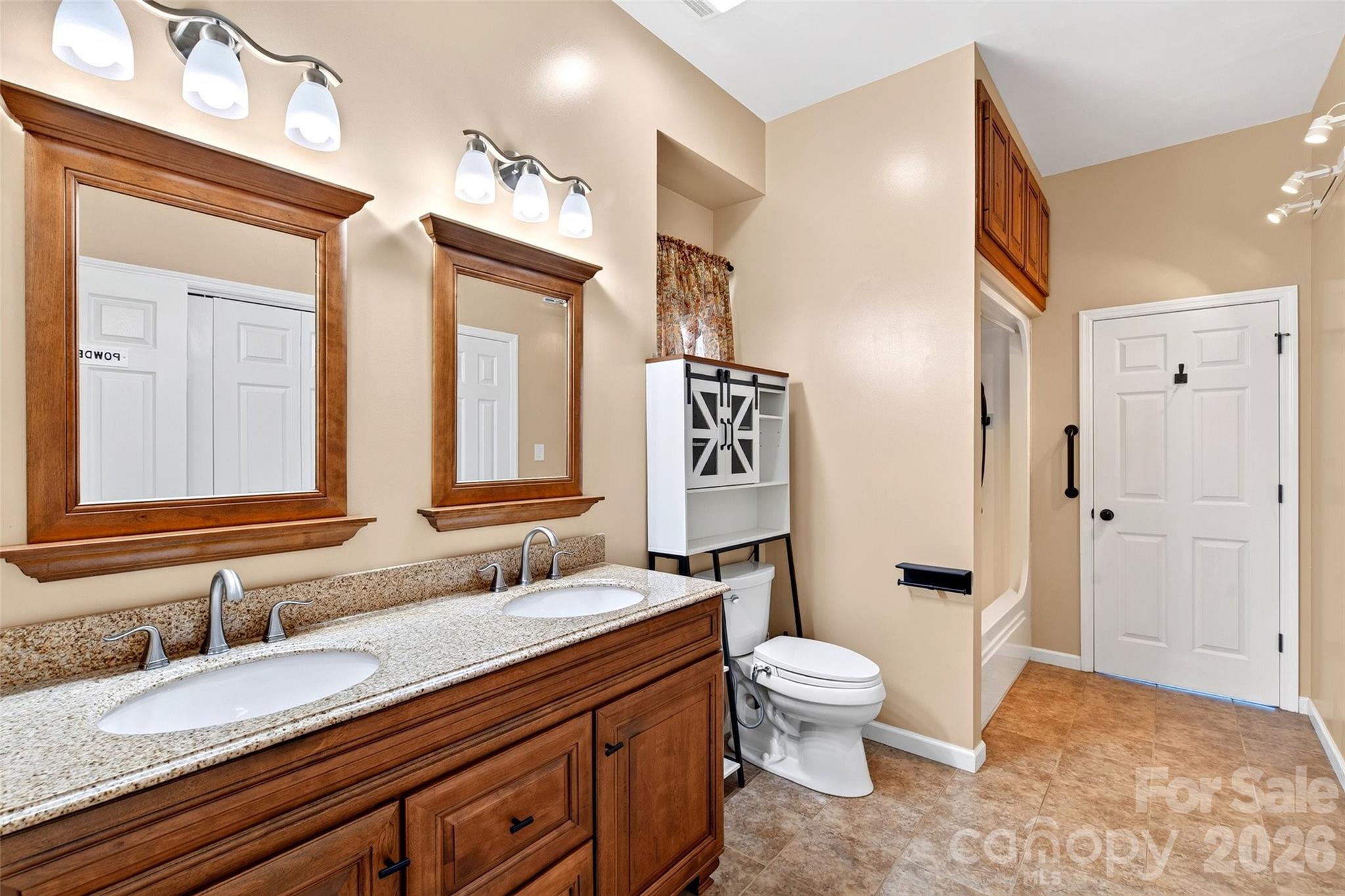 Primary bath with wood vanity, framed mirror, and glass walk-in shower. - 831 Lake Club Drive, Nebo